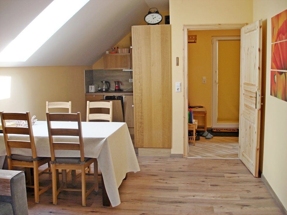 Essbereich einer Ferienwohnung mit Tisch, Stühlen und Küchenzeile.