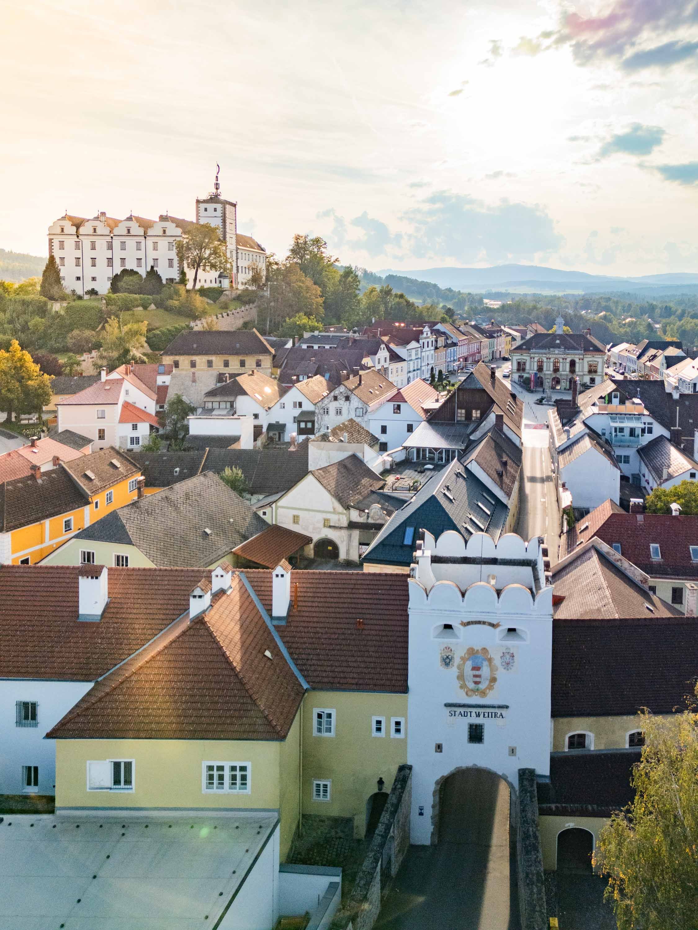 Luftaufnahme der historischen Altstadt von Weitra mit Schloss und Stadttor im Vordergrund.