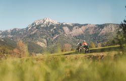 Zwei Radfahrerinnen auf dem Traisental-Radweg, Bergpanorama im Hintergrund.