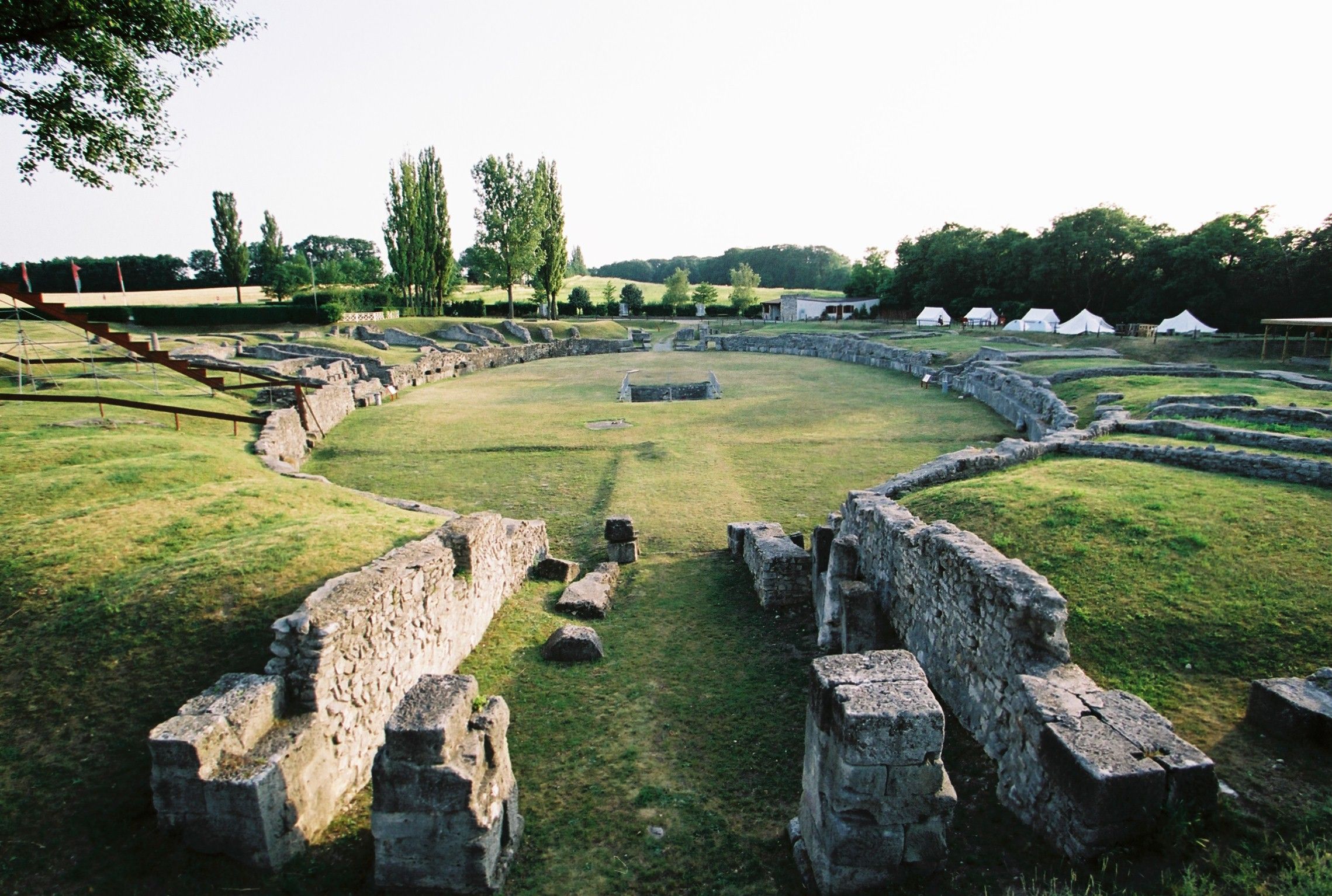 Ruinen eines antiken Amphitheaters mit umliegender grüner Landschaft.