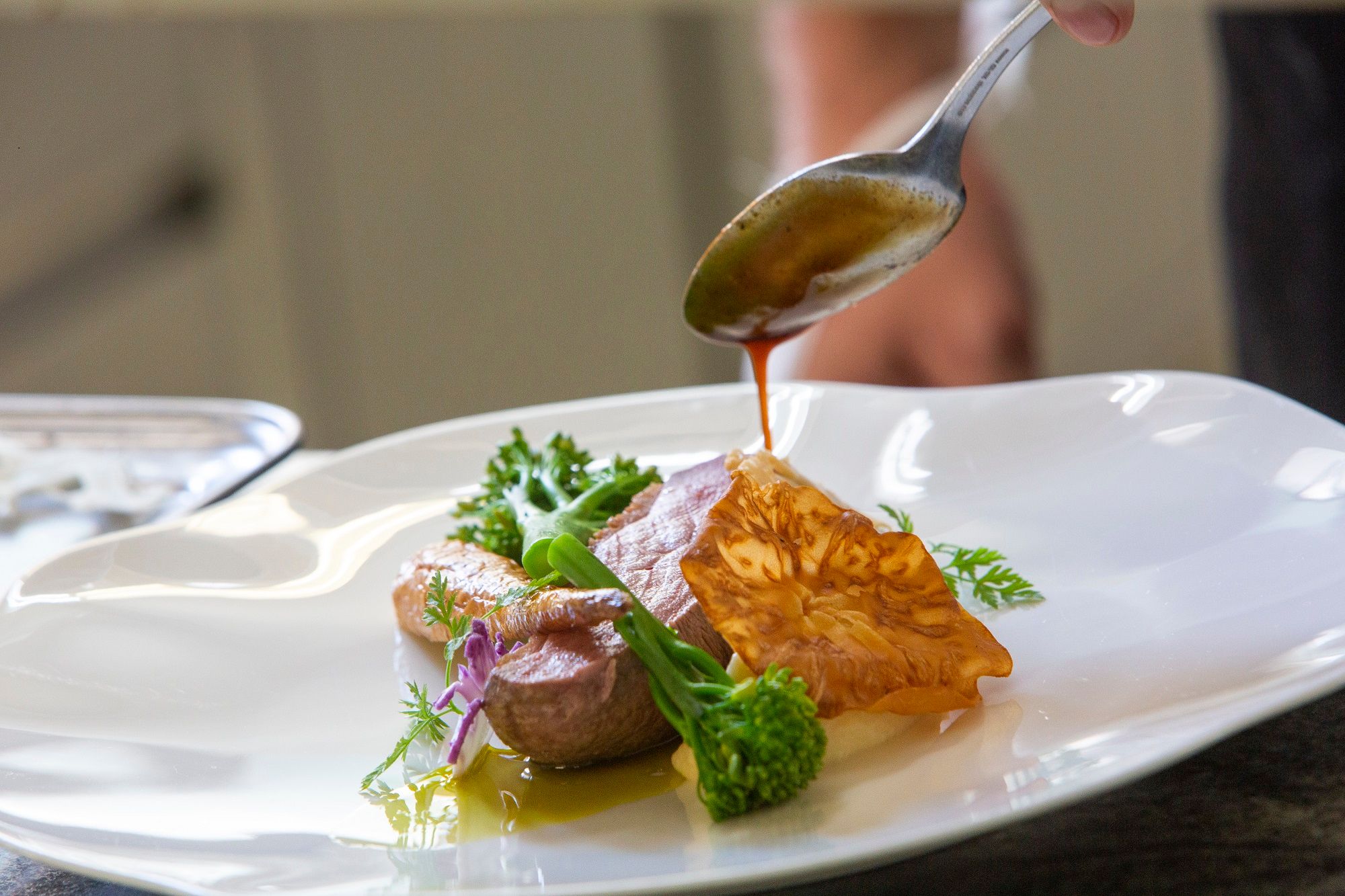 Ein Gourmetgericht wird mit einer Sauce verfeinert.