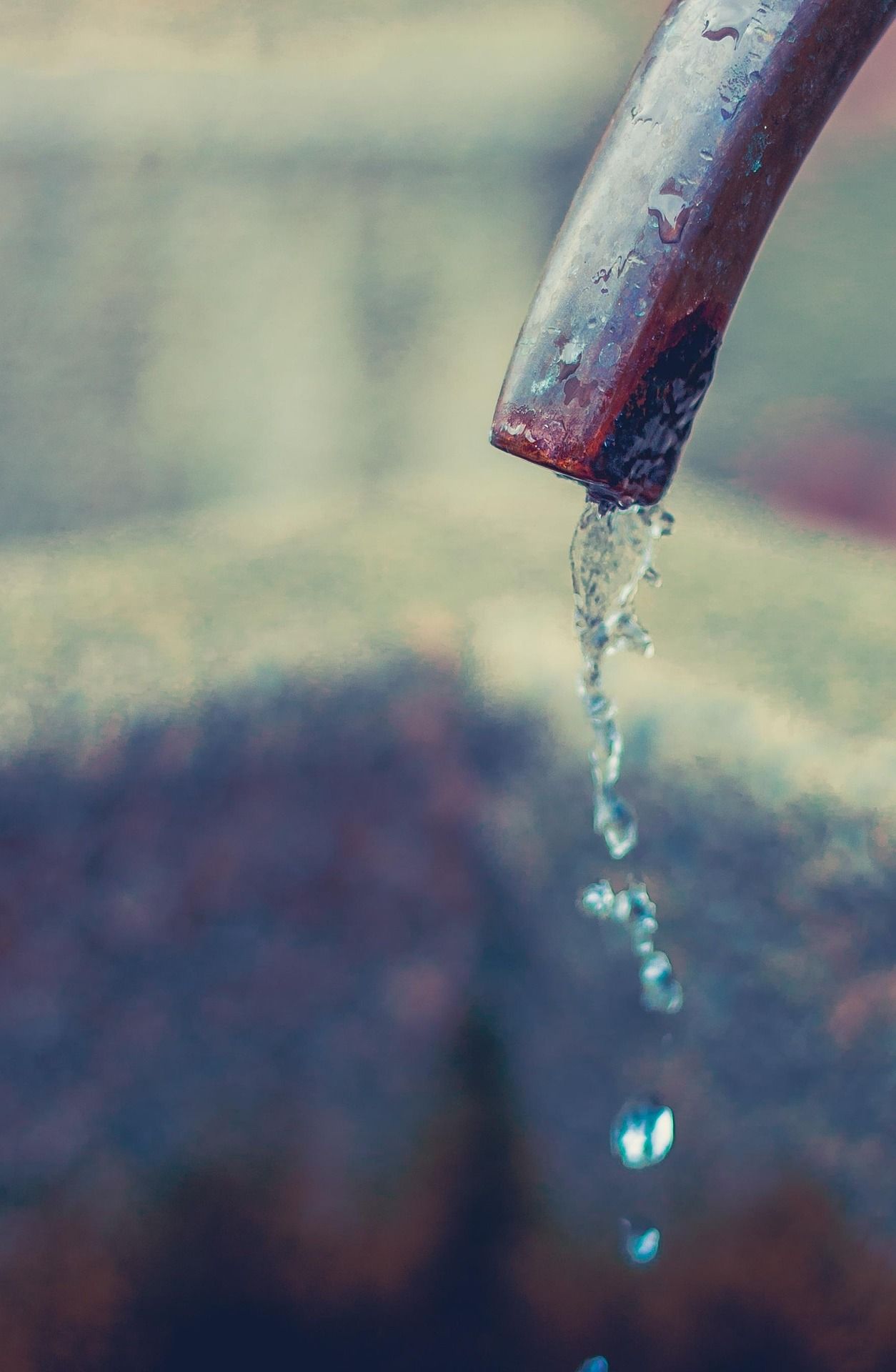 Nahaufnahme eines Wasserstrahls, der aus einem Metallrohr fließt.