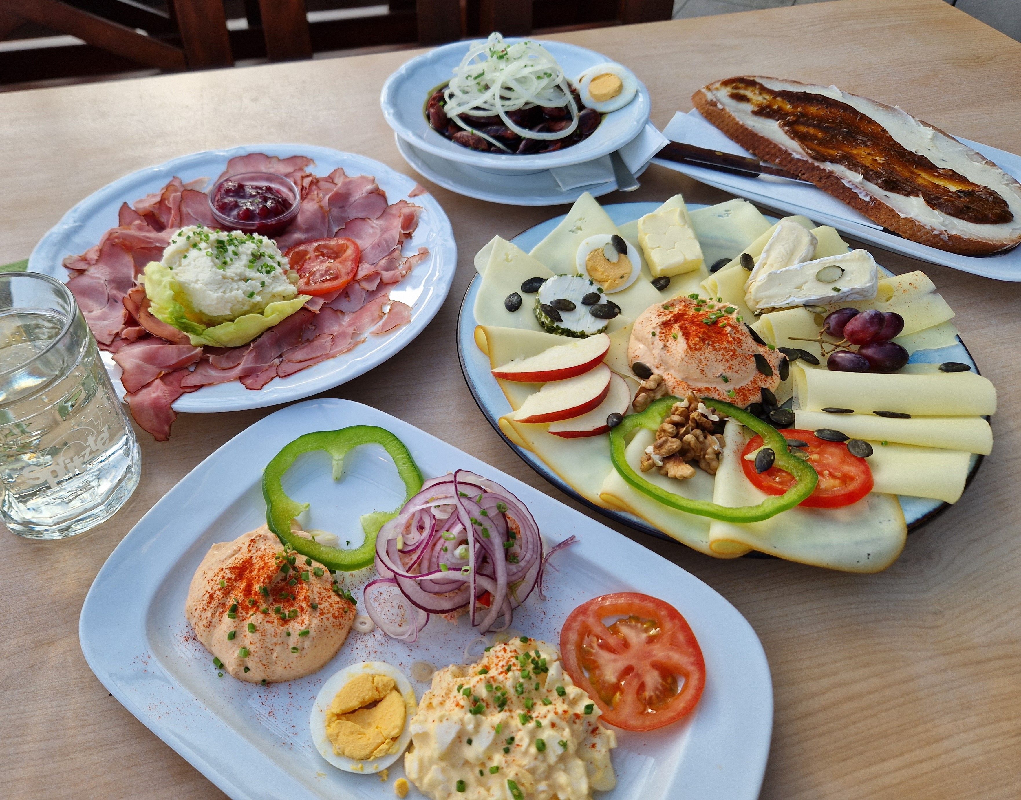 Verschiedene österreichische Heurigenjause-Gerichte auf einem Tisch.