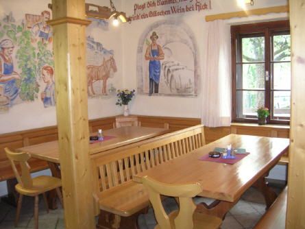 Gemütliche Weinstube mit Holzmöbeln und Wandmalereien.