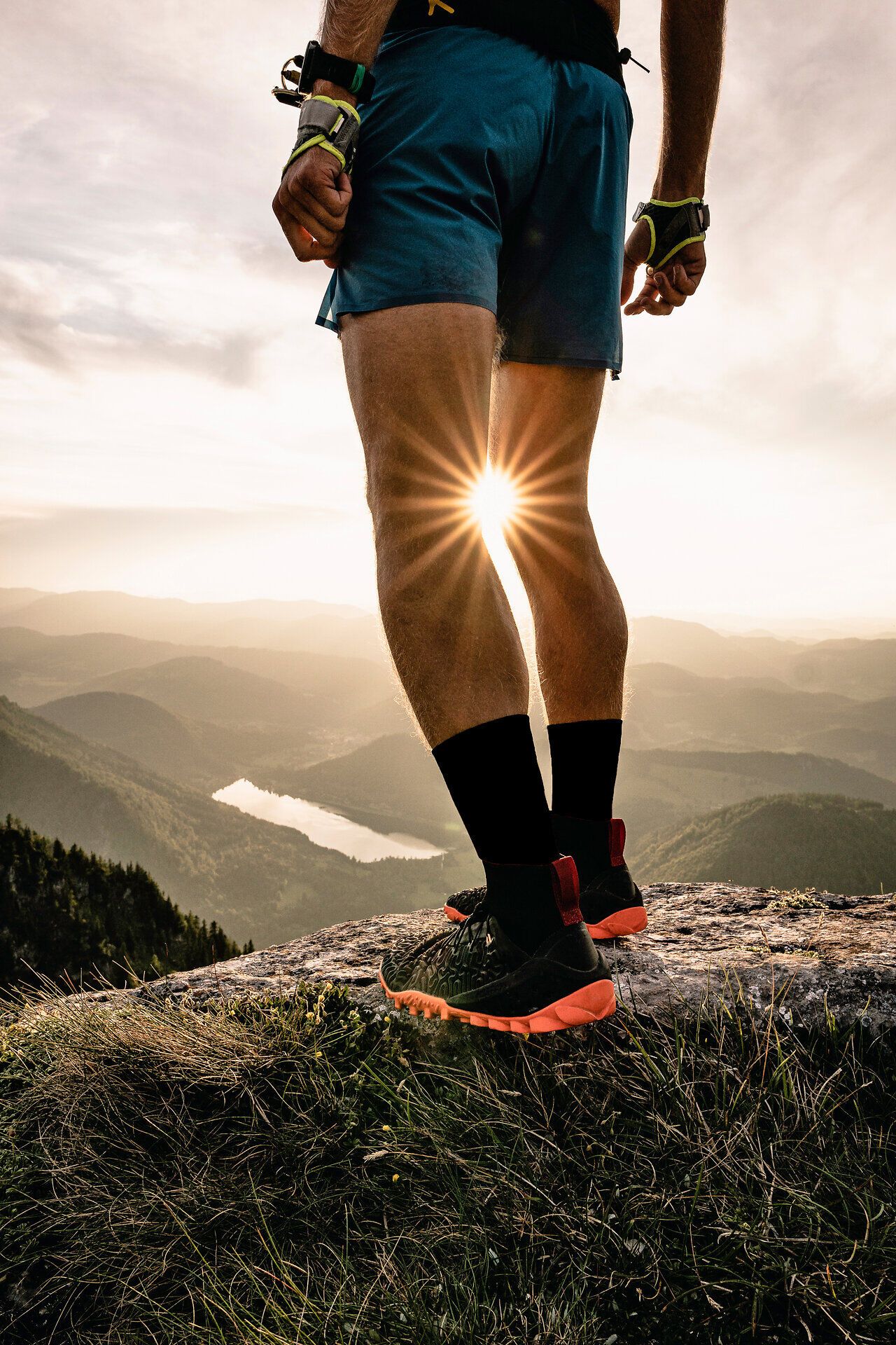 Die Sonne strahlt durch die Berge und taucht die Landschaft in ein warmes Licht. Ein Trailrunner genießt den atemberaubenden Ausblick vom Scheiblingstein auf die sanften Hügel und den glitzernden Lunzer See, während er die frische Bergluft einatmet. Diese Szenerie lädt dazu ein, die Schönheit der Natur zu erleben und die Seele baumeln zu lassen.