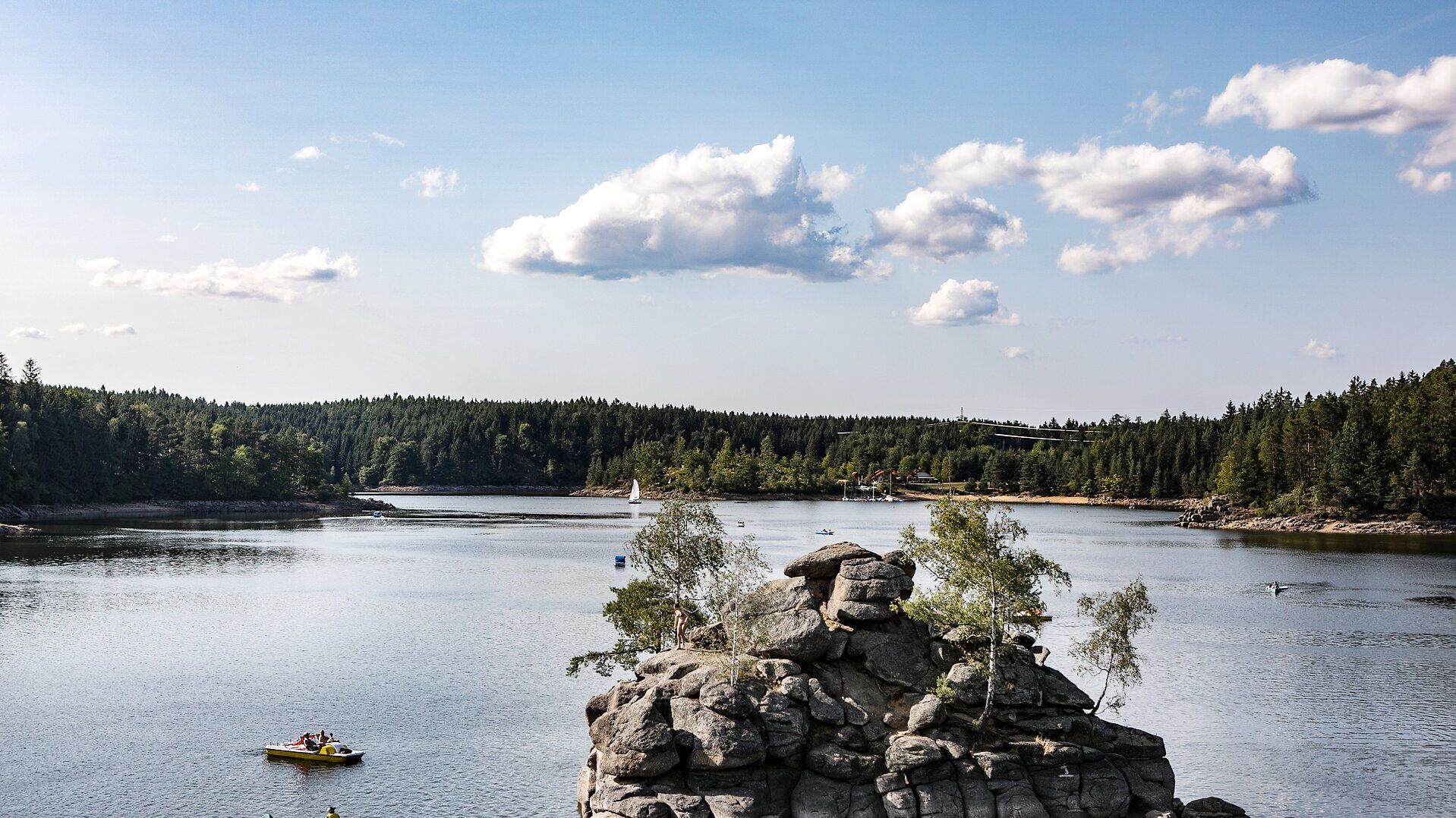 Der Ottensteiner Stausee strahlt an einem sonnigen Sommertag eine friedliche Atmosphäre aus. Kajakfahrer gleiten sanft über das glitzernde Wasser, während die umgebenden Wälder eine ruhige Kulisse bieten. Hier erleben Besucher die perfekte Kombination aus Natur und Erholung.