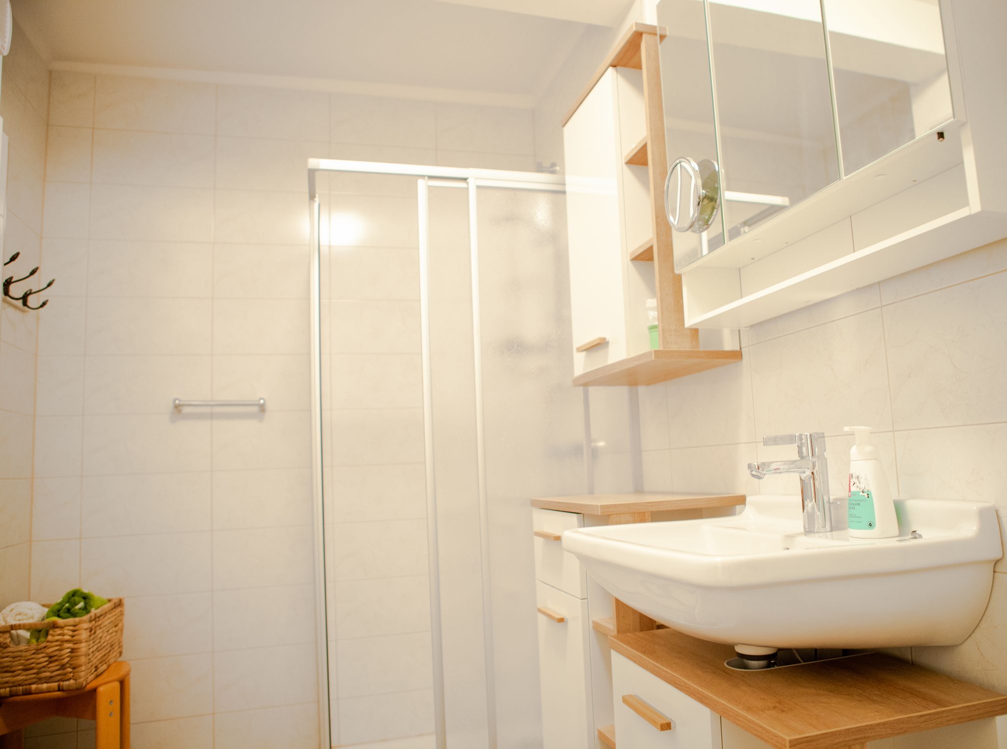 Modernes Badezimmer mit Dusche, Waschbecken und Spiegel.