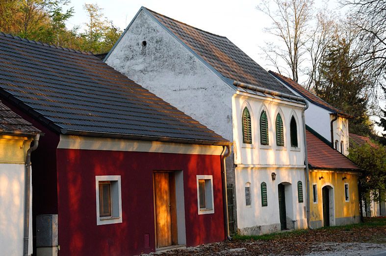Traditionelle Weinkeller in der Kellergasse Absberg mit bunten Fassaden und grünen Fensterläden.