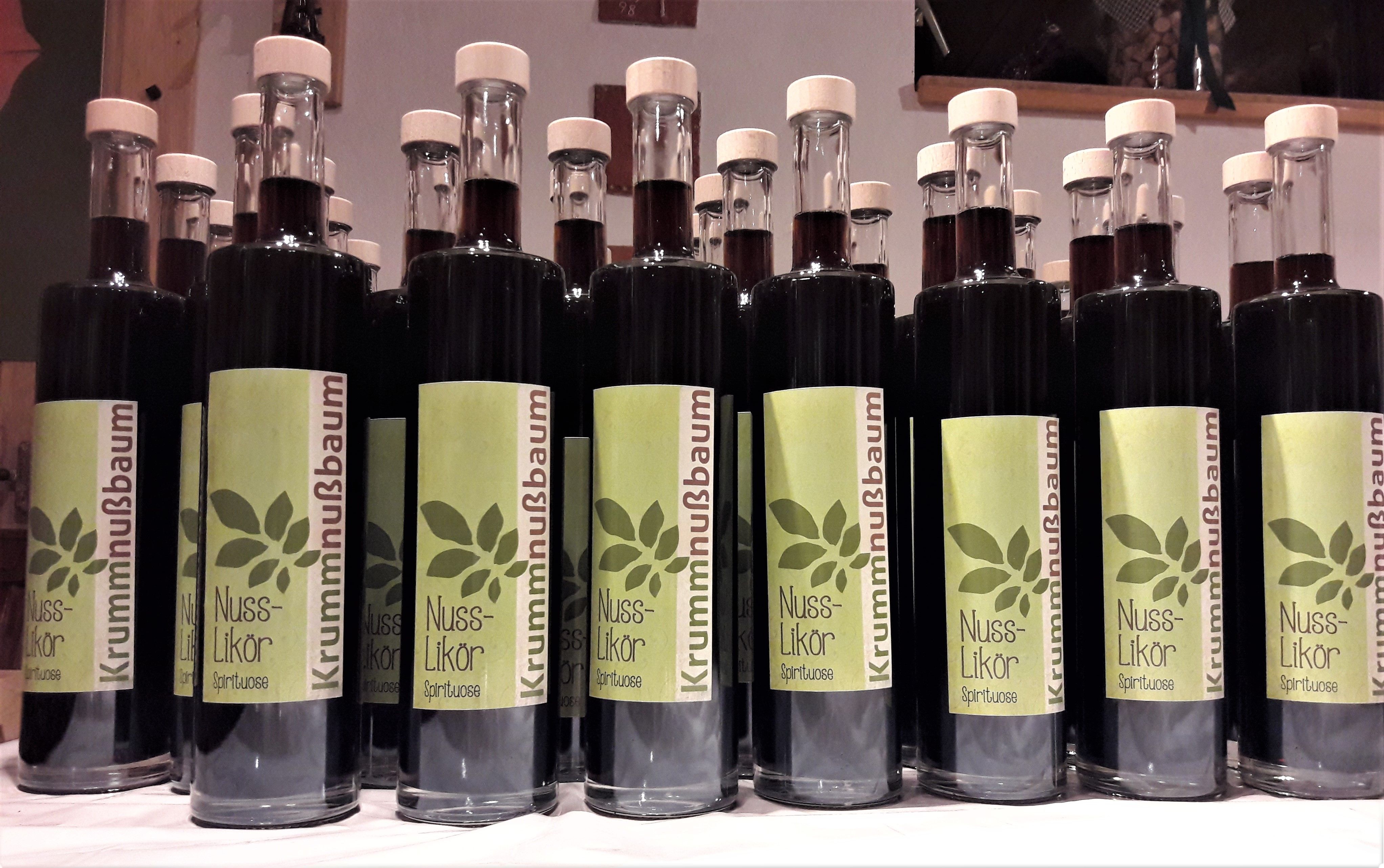 Reihe von Flaschen mit Nusslikör und grünen Etiketten.