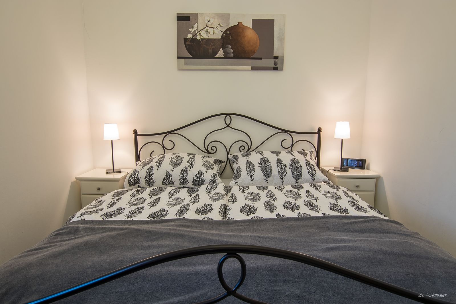 Schlafzimmer mit Doppelbett, zwei Nachttischen und Lampen.