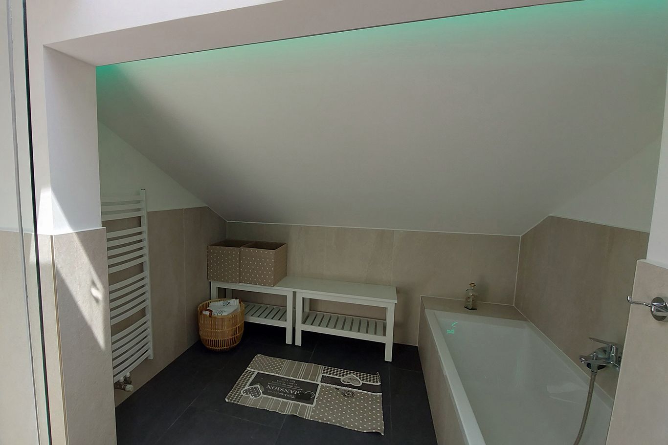 Modernes Badezimmer mit Badewanne, Dachschräge, Handtuchhalter und Dekoration.