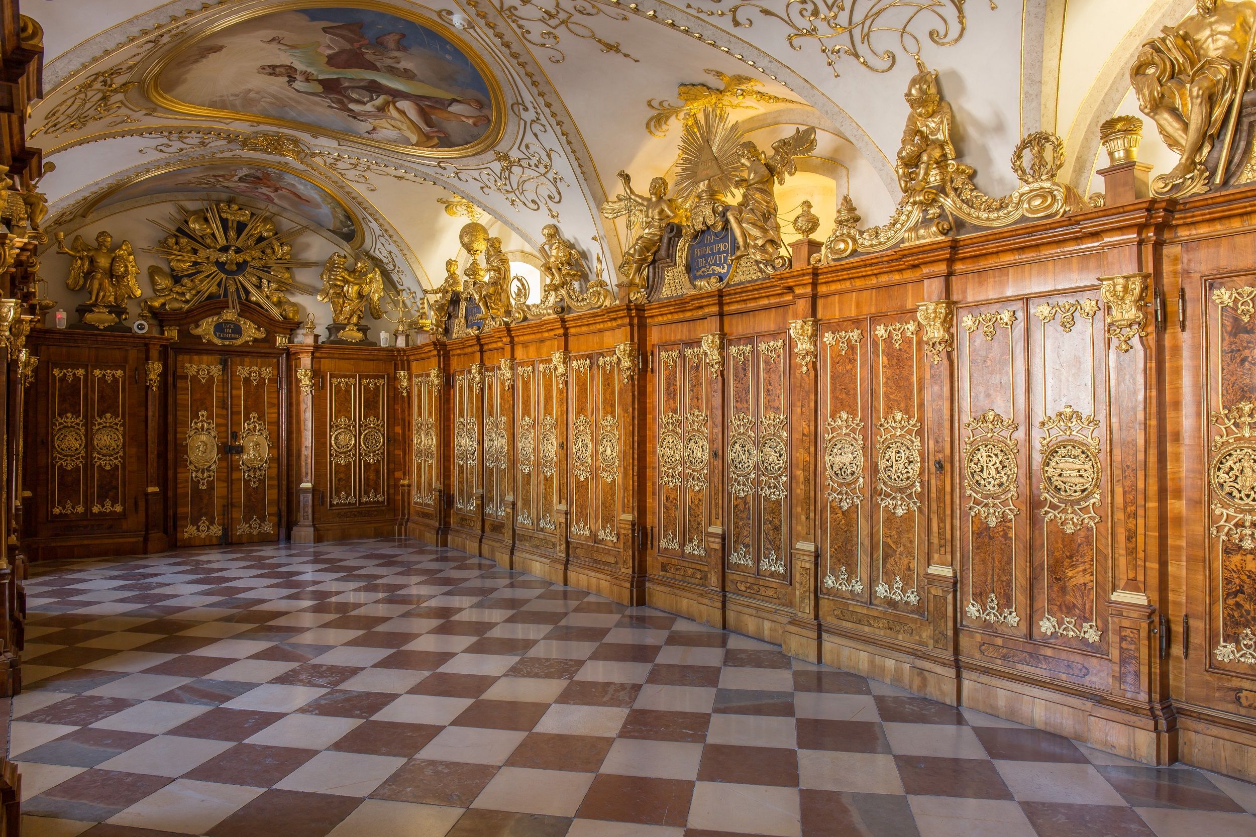 Prunkvoller Raum mit verzierten Holzpaneelen und Deckenmalerei.