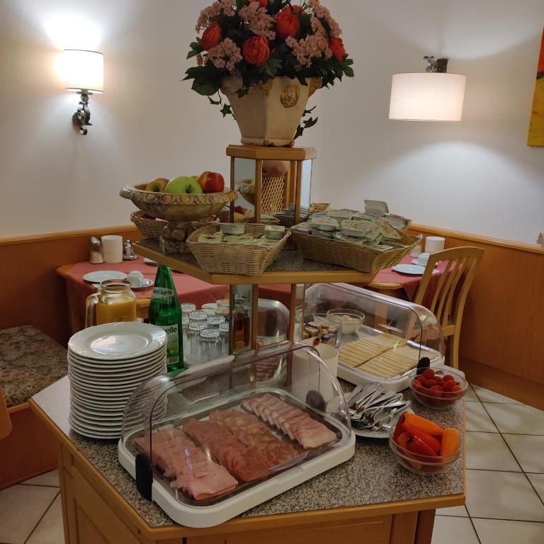 Frühstücksbuffet mit Aufschnitt, Käse, Obst und Getränken.