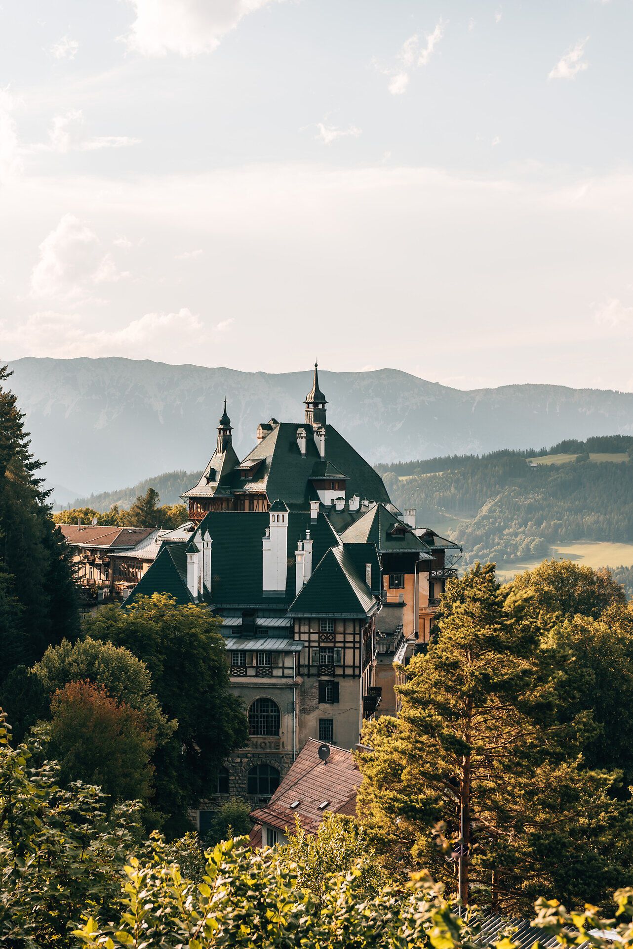 Umgeben von majestätischen Bergen und üppigem Grün strahlt das beeindruckende Bauwerk eine einladende Atmosphäre aus. Die sanften Hügel und die klare Luft laden dazu ein, die Schönheit der Natur zu genießen und unvergessliche Sommertage zu verbringen.