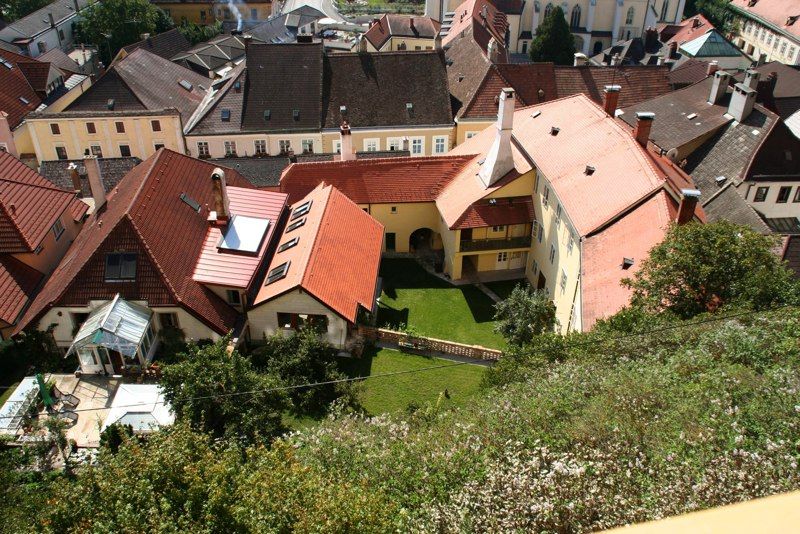 Luftaufnahme von Häusern mit roten Dächern und einem grünen Innenhof.