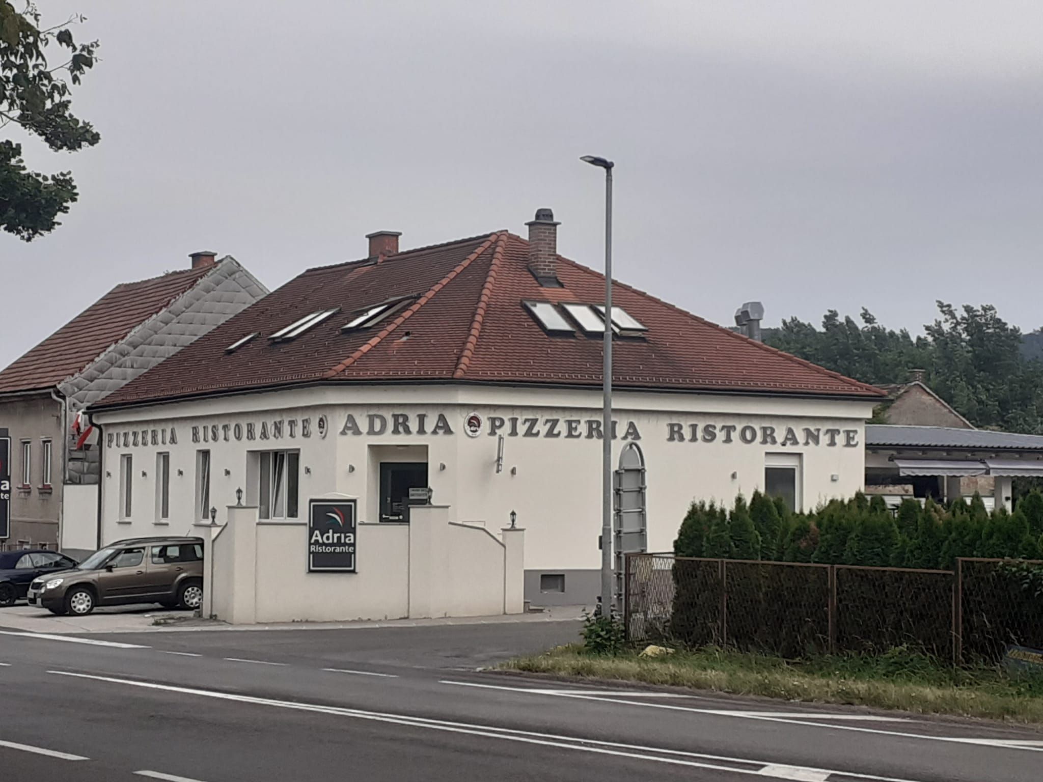Außenansicht eines Restaurants mit der Aufschrift 'Adria Pizzeria Ristorante'.