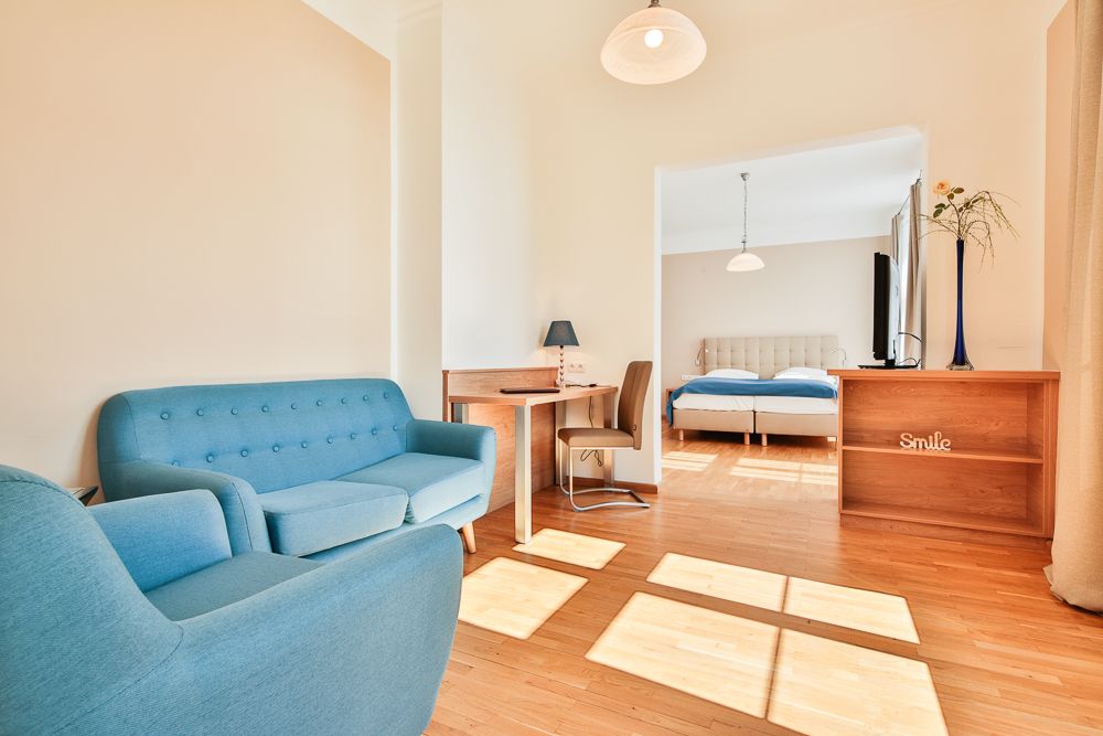 Helles Hotelzimmer mit blauen Möbeln und Doppelbett.