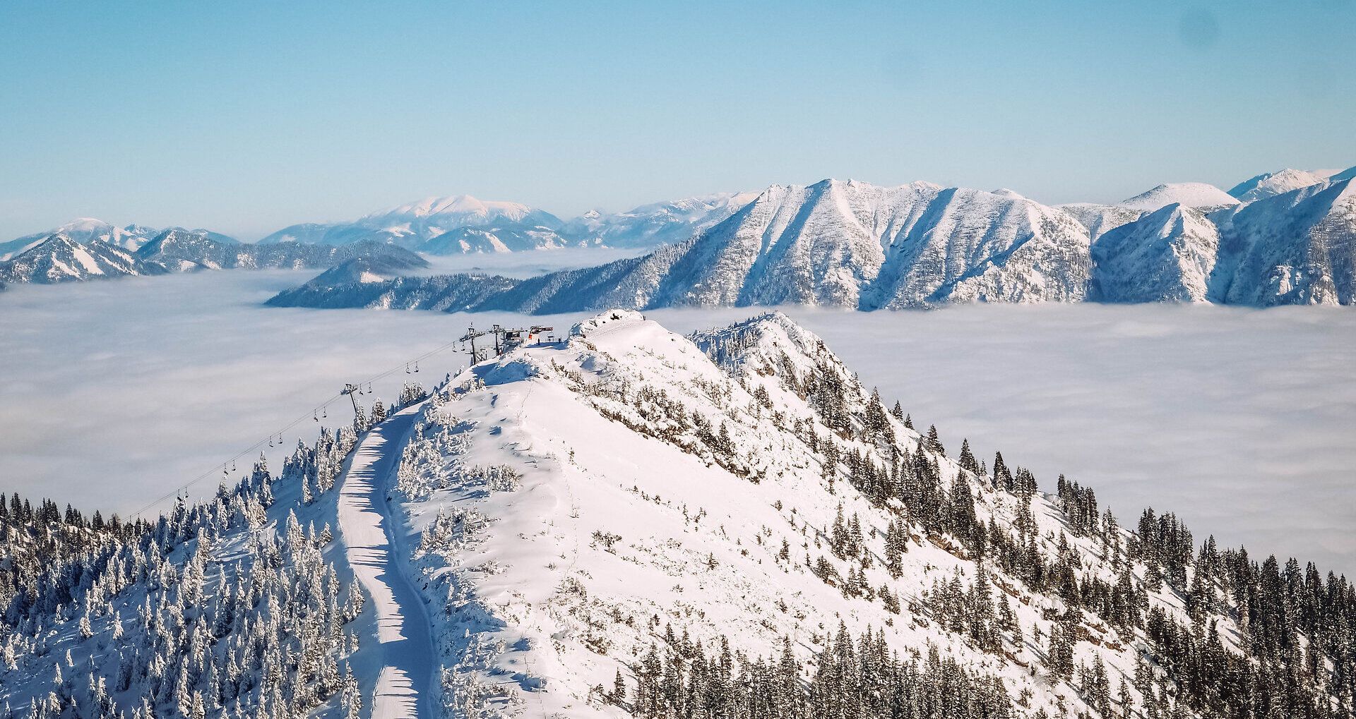 Die schneebedeckten Gipfel erstrahlen im Sonnenlicht und laden Familien zu unvergesslichen Abenteuern ein. Die klare, kalte Luft und die glitzernde Schneedecke schaffen eine magische Winterlandschaft, die zum Spielen und Entspannen einlädt.