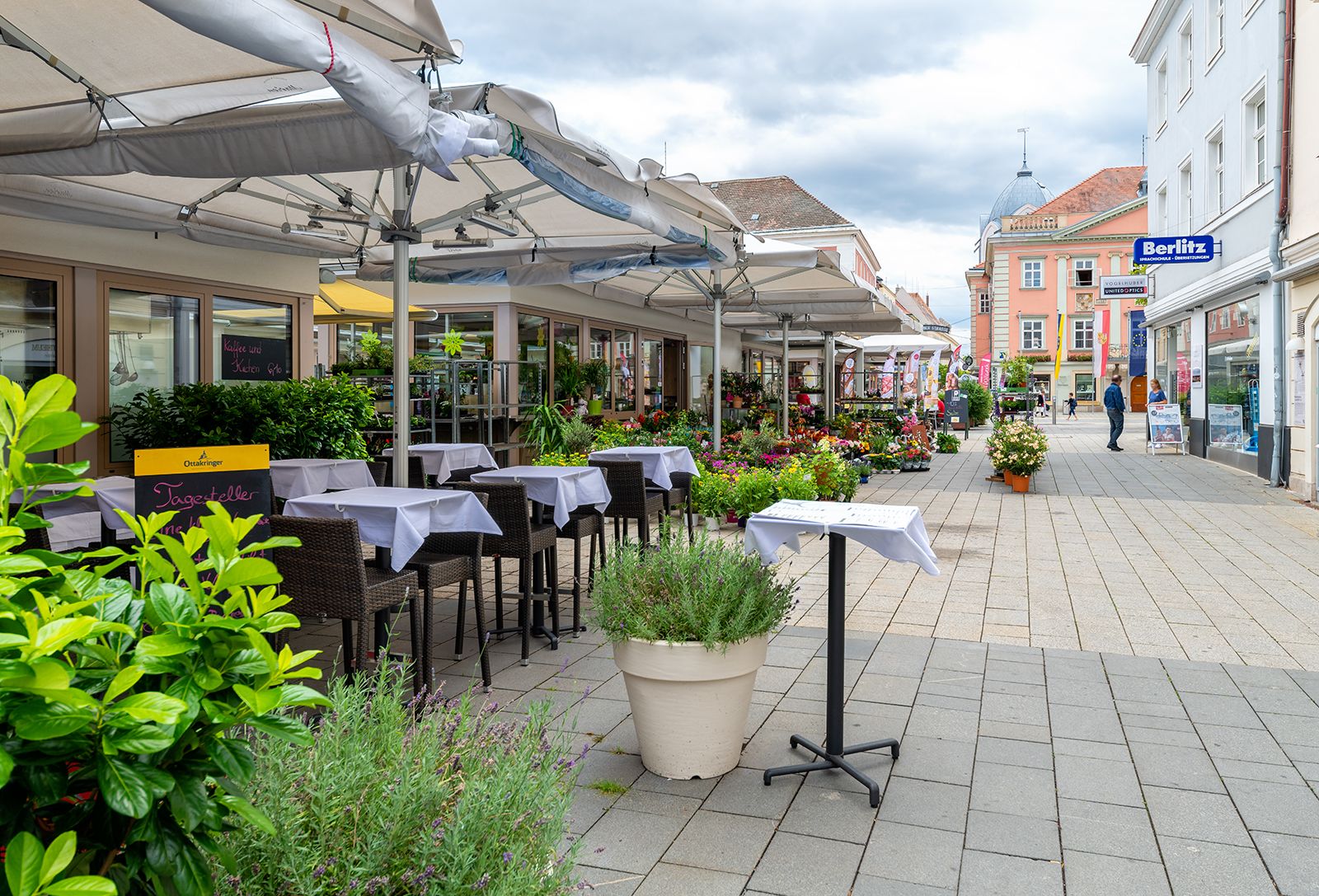Straßenszene in Wiener Neustadt mit Cafés und Geschäften.