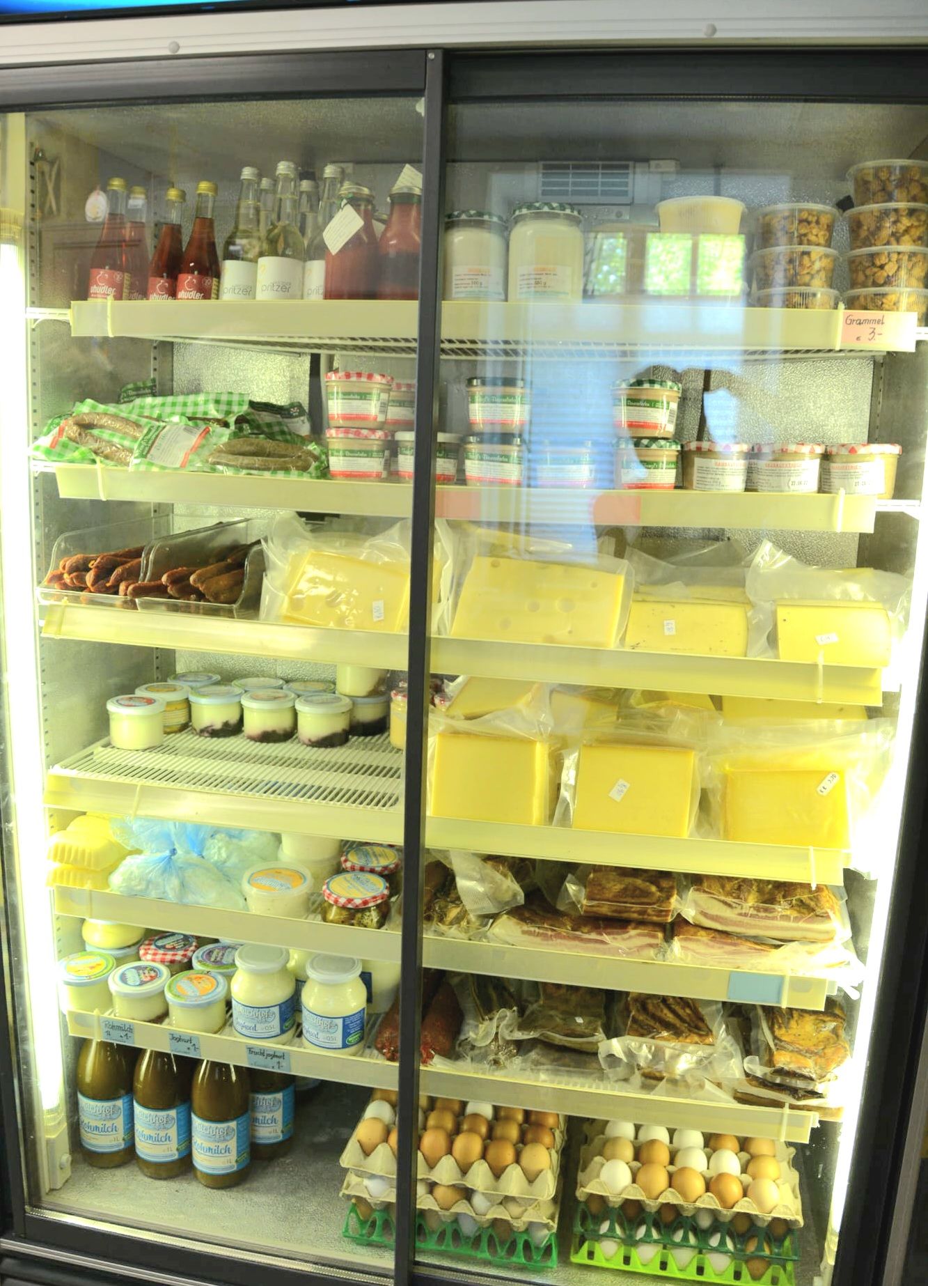 Kühlschrank mit verschiedenen Milchprodukten, Fleisch und Eiern.