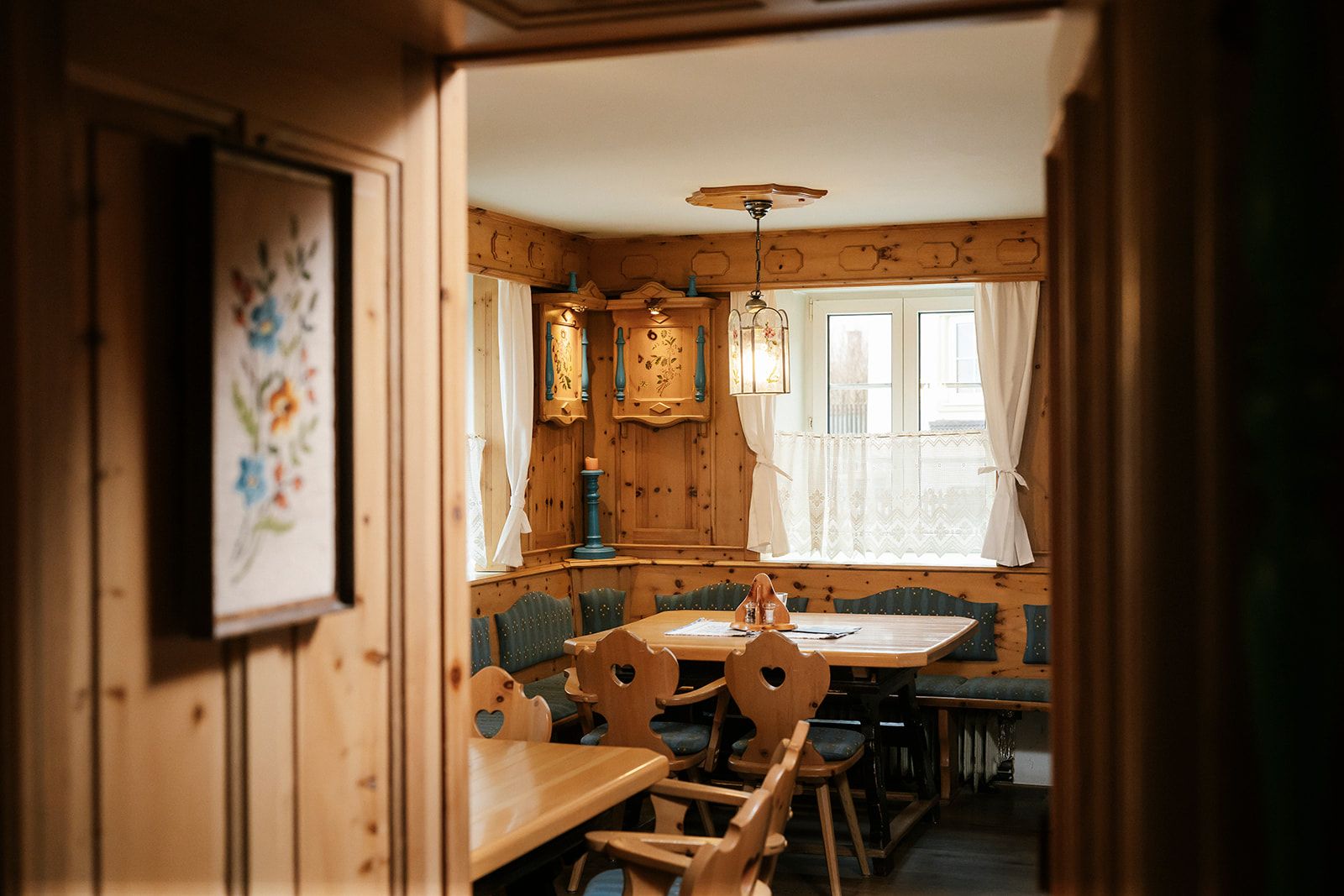 Gemütliche, rustikale Stube mit Holzmöbeln und dekorativen Elementen.