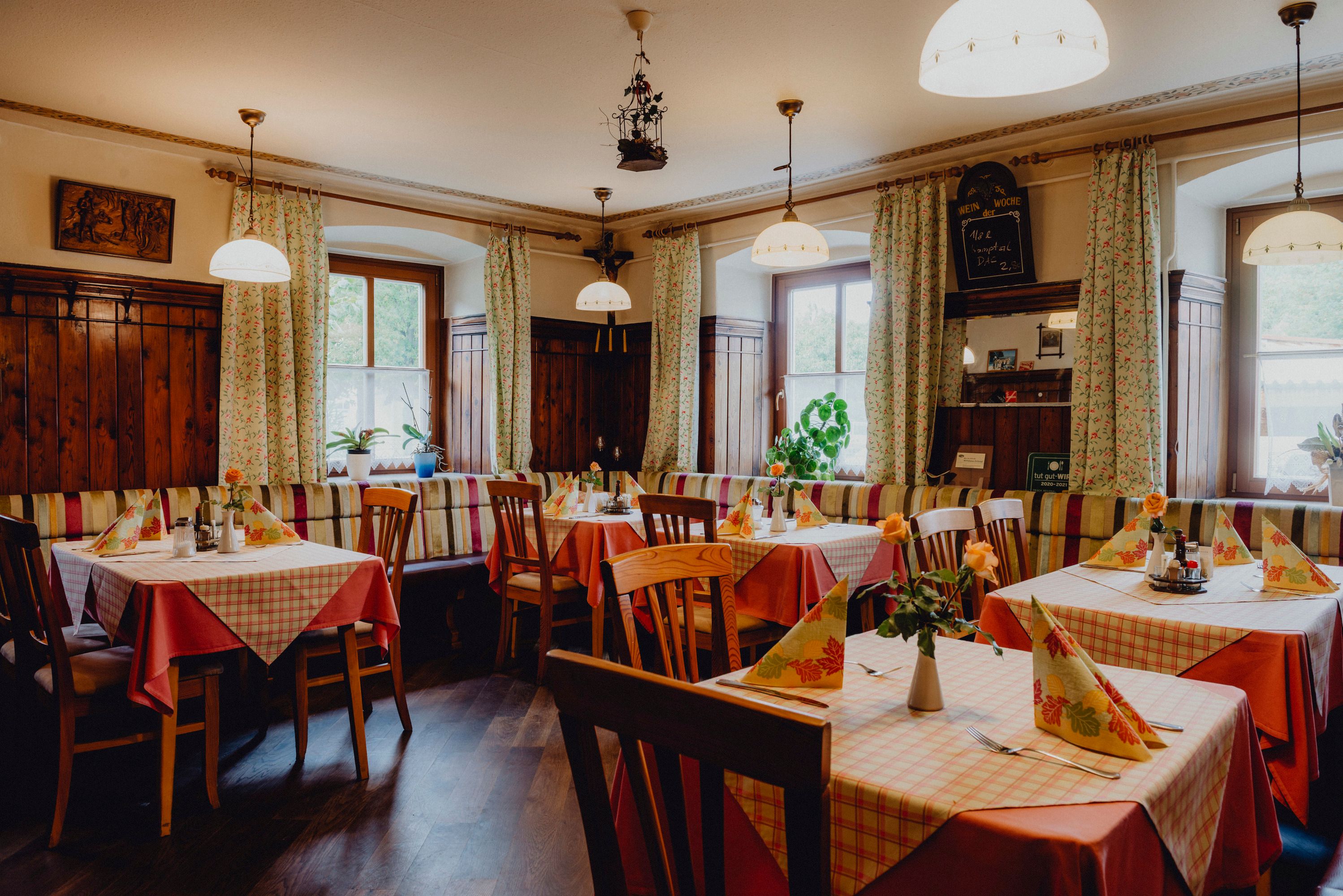 Gemütliches Gasthaus mit Holzmöbeln und karierten Tischdecken.