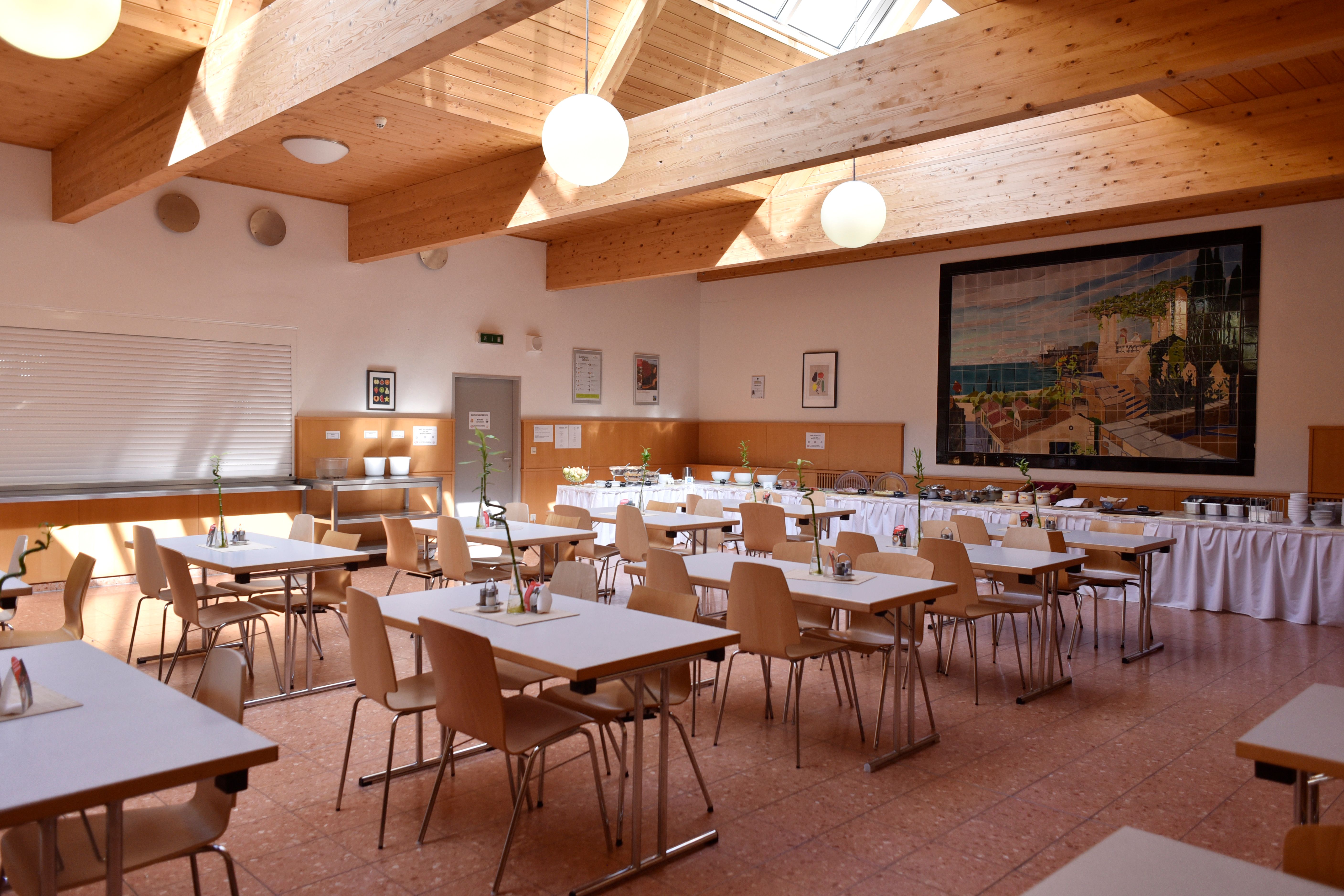 Frühstücksraum aufgedeckt mit Tischen für eine Gruppe 