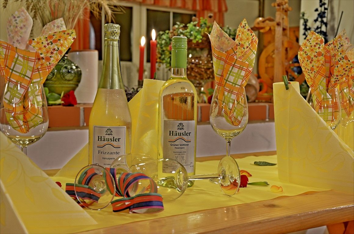 Festlich gedeckter Tisch mit Weinflaschen und Gläsern.