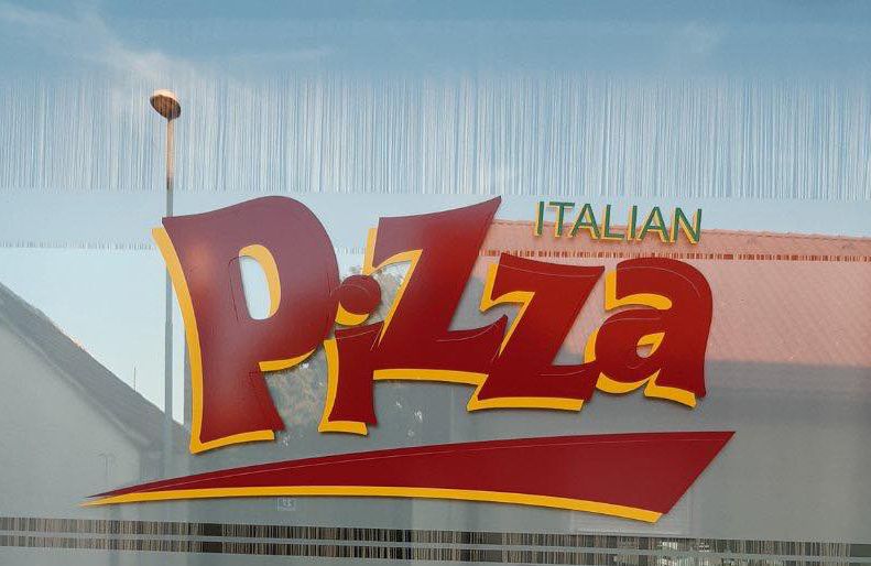 Fensterscheibe mit großem Schriftzug 'Italian Pizza' in Rot und Gelb.