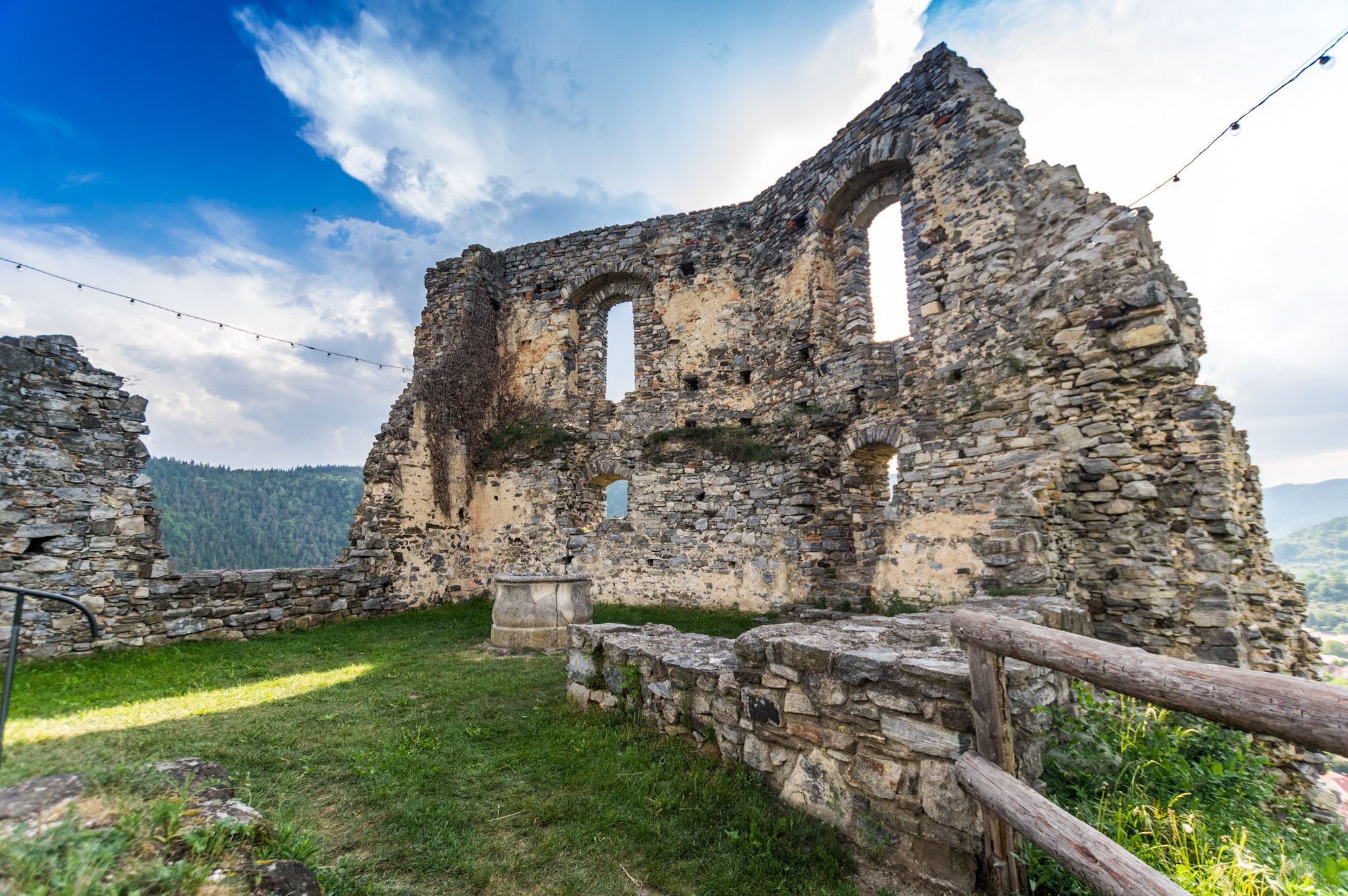 Ruine der Burgruine Senftenberg mit Steinmauern und Fenstern, umgeben von grüner Landschaft und blauem Himmel.
