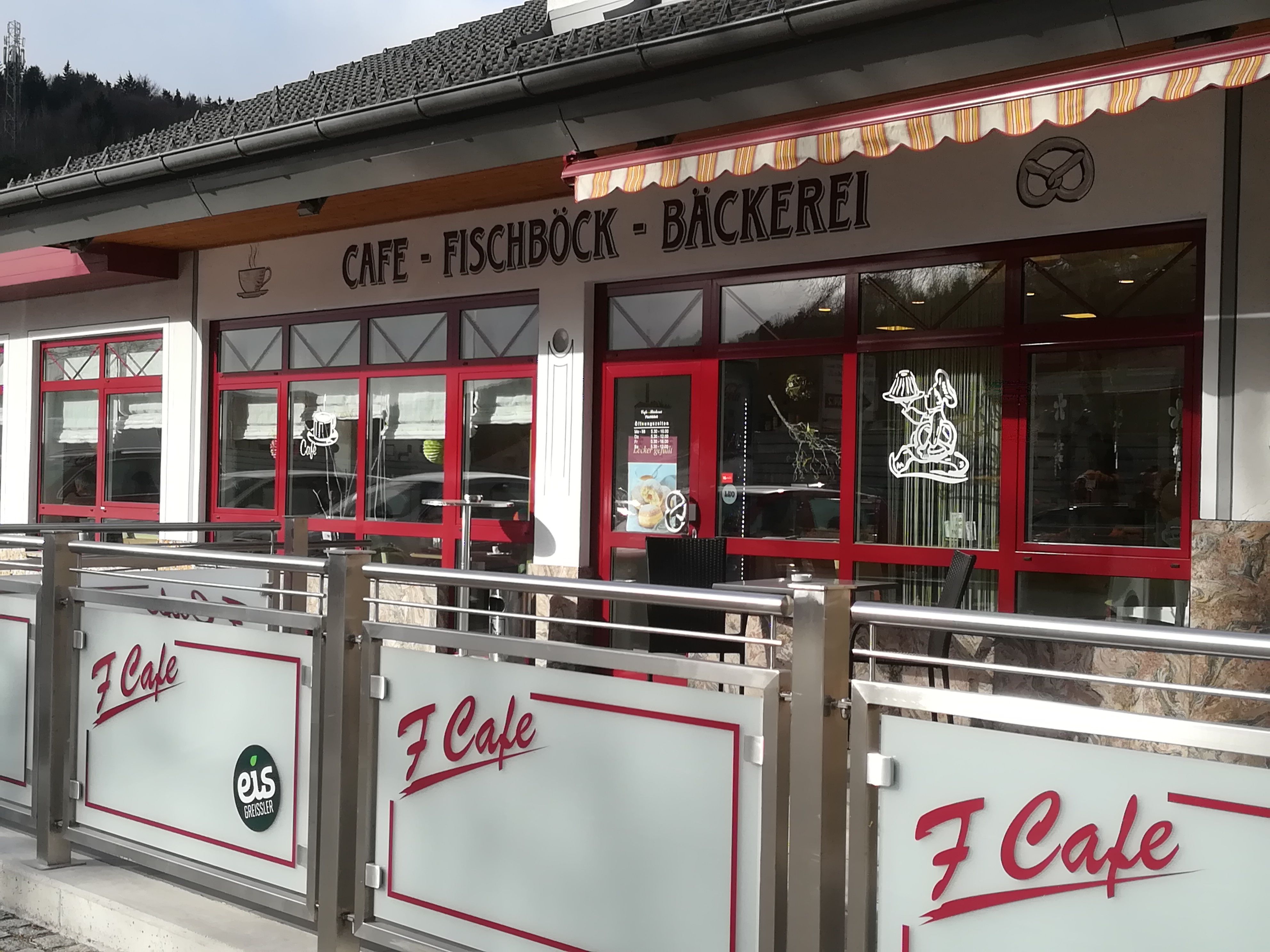 Außenansicht eines Cafés mit rotem Rahmen und Beschriftung 'Café Fischböck Bäckerei'.