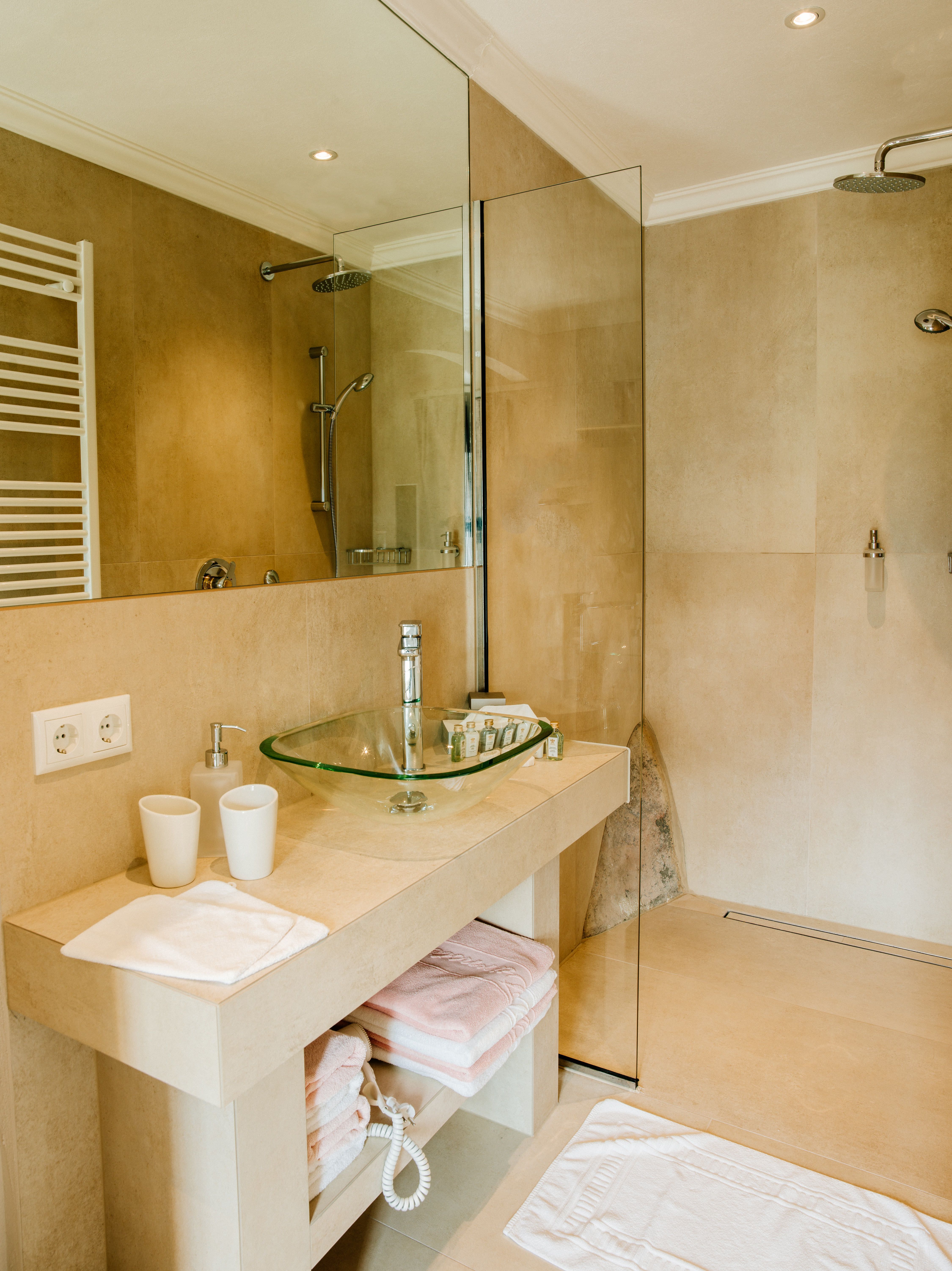 Modernes Badezimmer mit Glaswaschbecken und begehbarer Dusche.