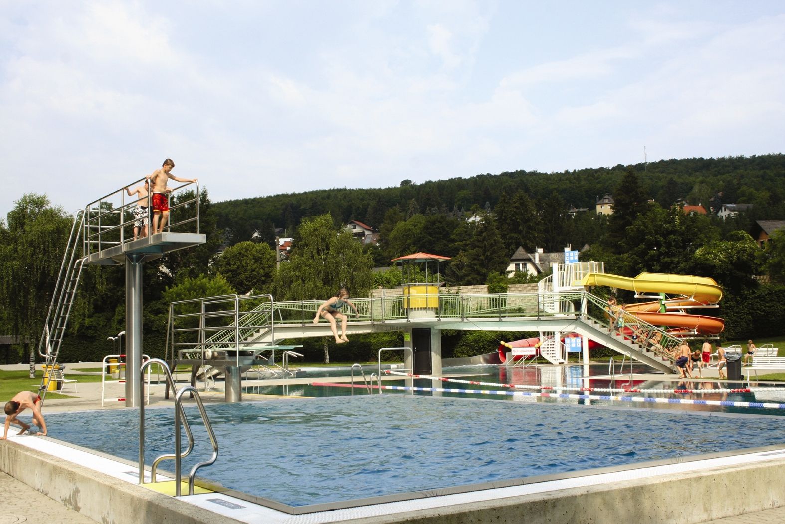 Das Wienerwaldbad in Purkersdorf mit Schwimmbecken, Sprungturm und Rutschen.