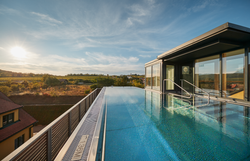 Gelbes Landgut mit roten Dächern und gepflegtem Garten.