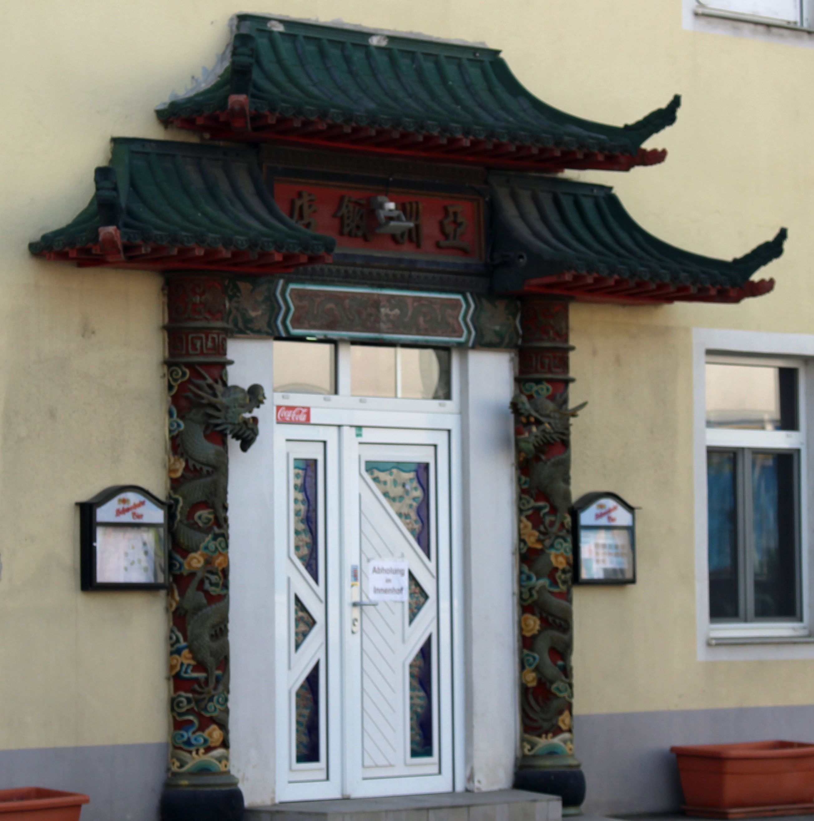 Eingang eines Chinarestaurants mit traditionellem chinesischen Dach und dekorativen Säulen.