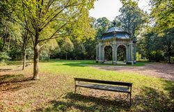 Der Schlosspark Laxenburg lädt mit seiner idyllischen Atmosphäre und den schattenspendenden Bäumen zu einem entspannten Spaziergang ein. Die kunstvoll gestaltete Pavillonstruktur, umgeben von üppigem Grün, bietet einen perfekten Ort für eine kleine Auszeit in der Natur.
