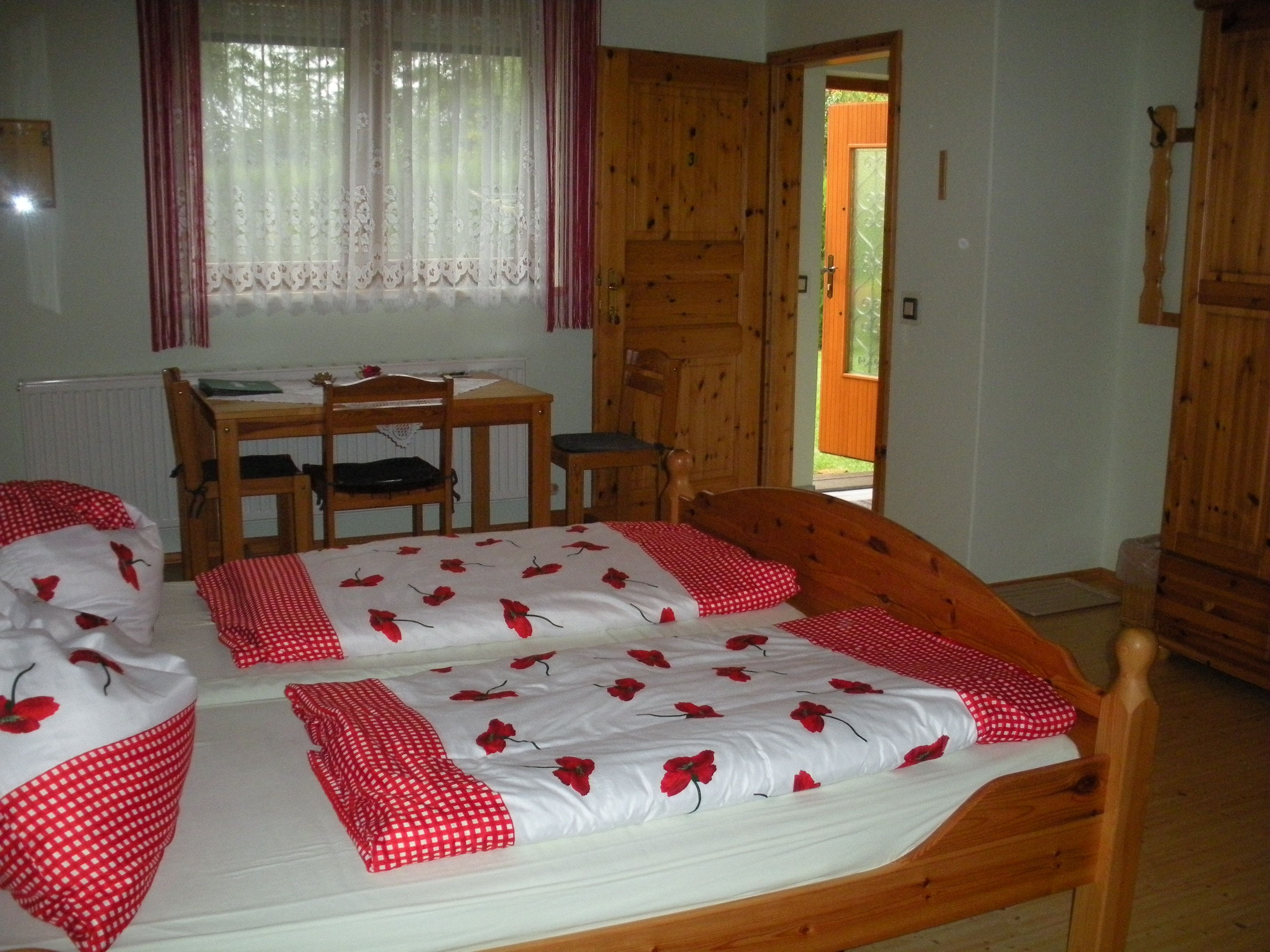 Gemütliches Gästezimmer mit Holzmöbeln, Doppelbett und Schreibtisch.
