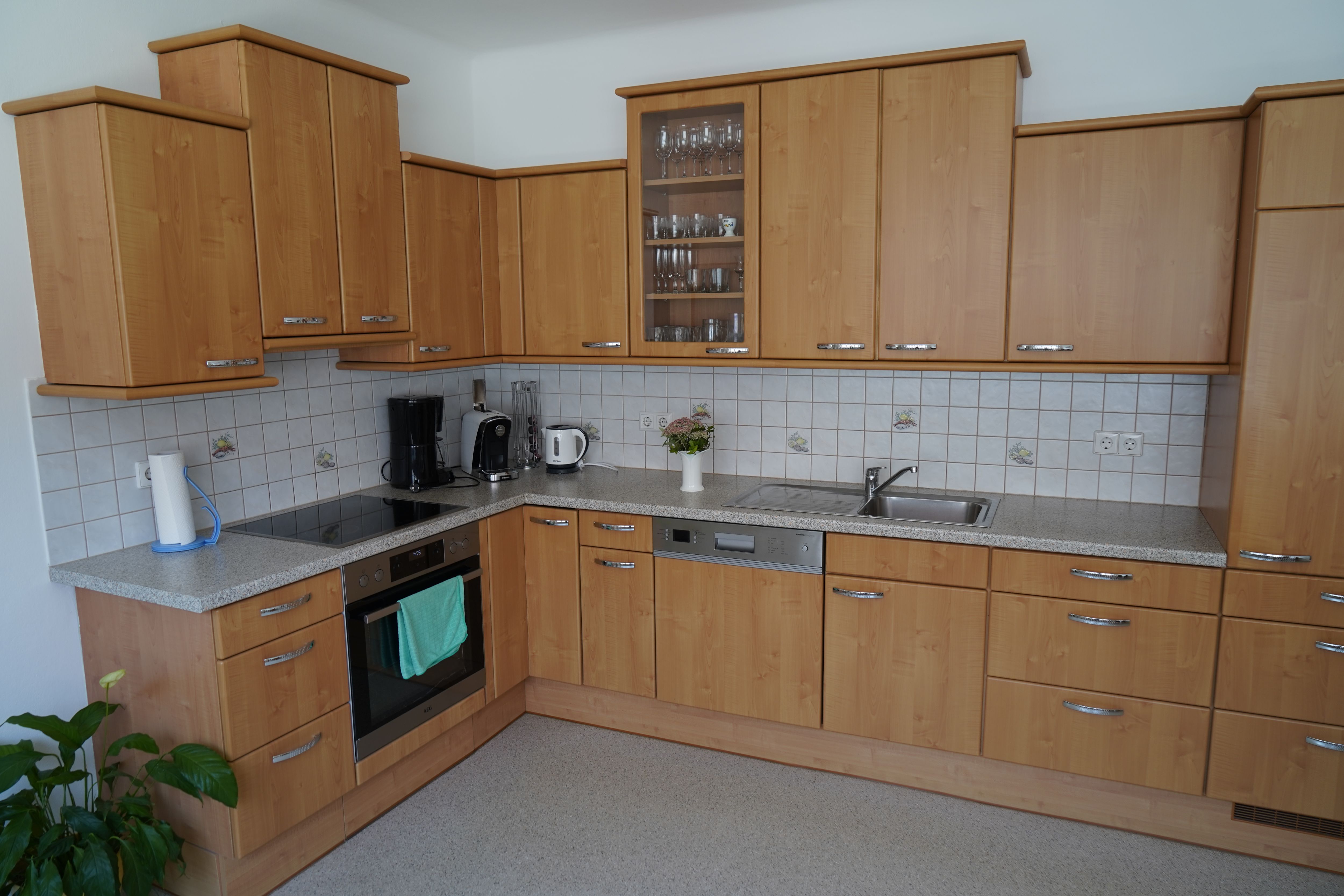 Moderne Küche mit Holzschränken, Elektrogeräten und Spüle.