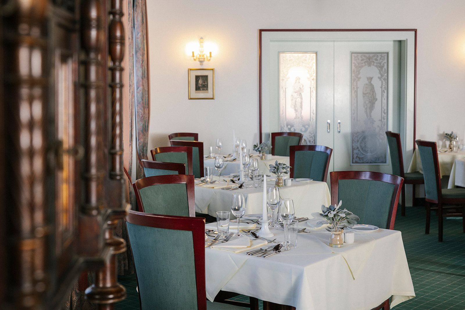 Elegantes Hotelrestaurant mit gedeckten Tischen und dekorativen Elementen.