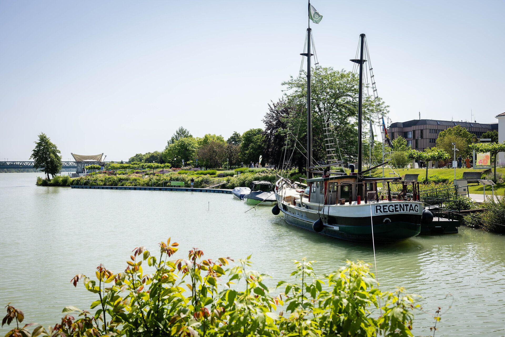 Regentag von Hundertwasser liegt am Hafen in Tulln, dahinter Donaulände und Donaubühne