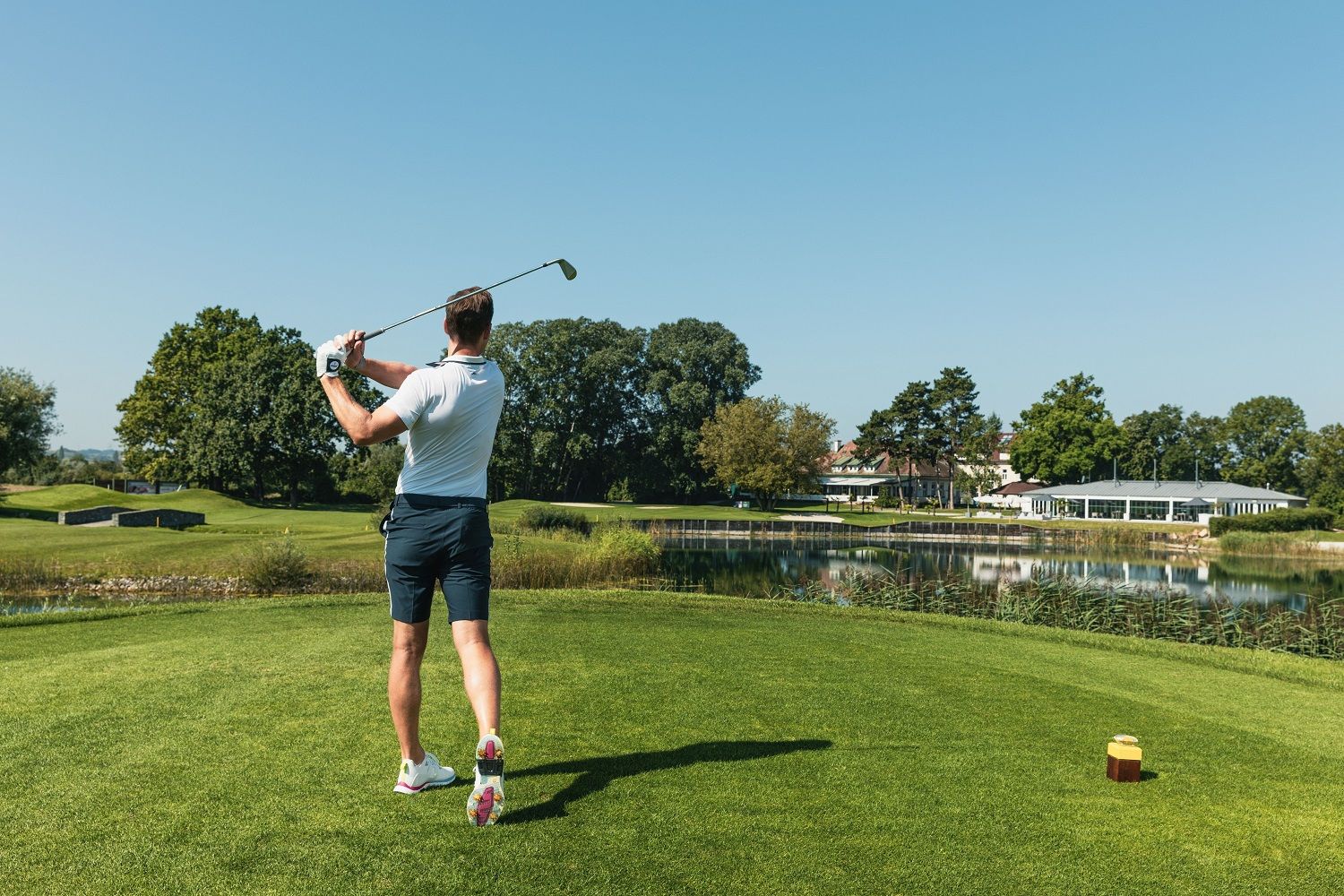 Golfspieler mit Golfschläger in der Hand, welcher gerade Golf spielt.