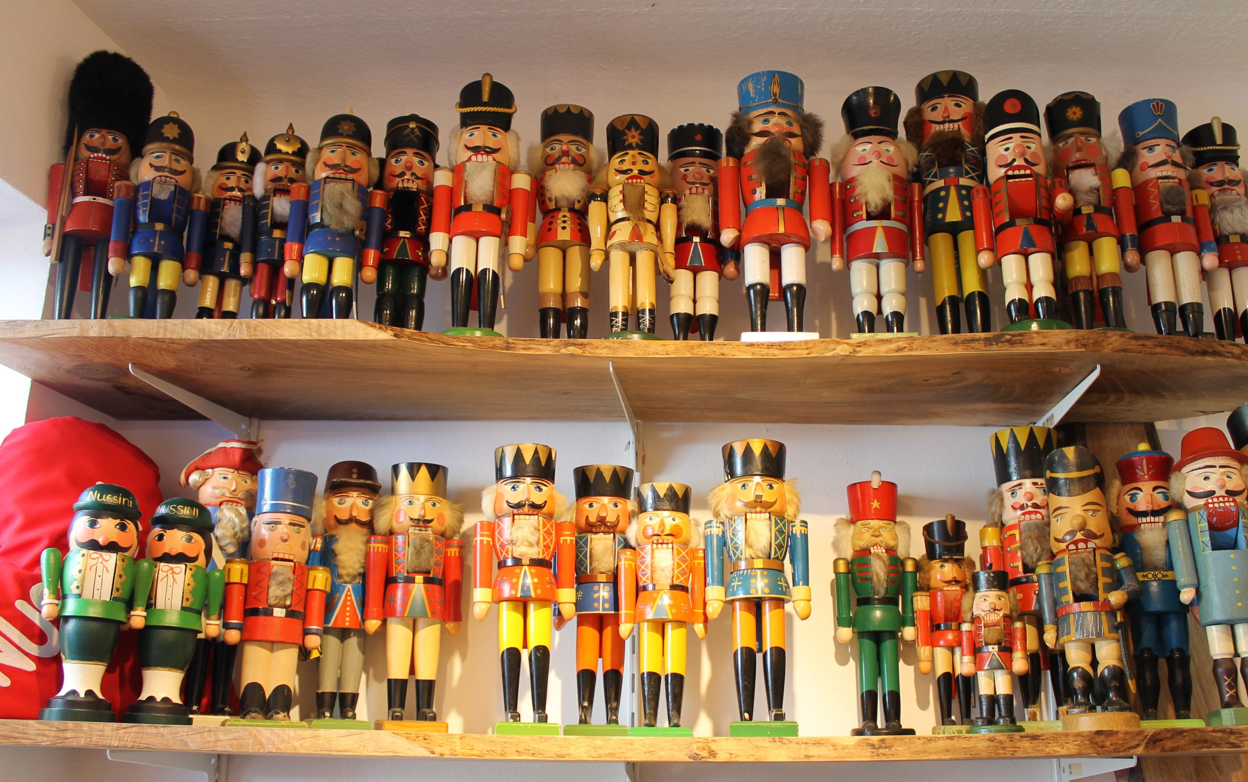 Regale mit vielen bunten Nussknackerfiguren in verschiedenen Uniformen und Farben.