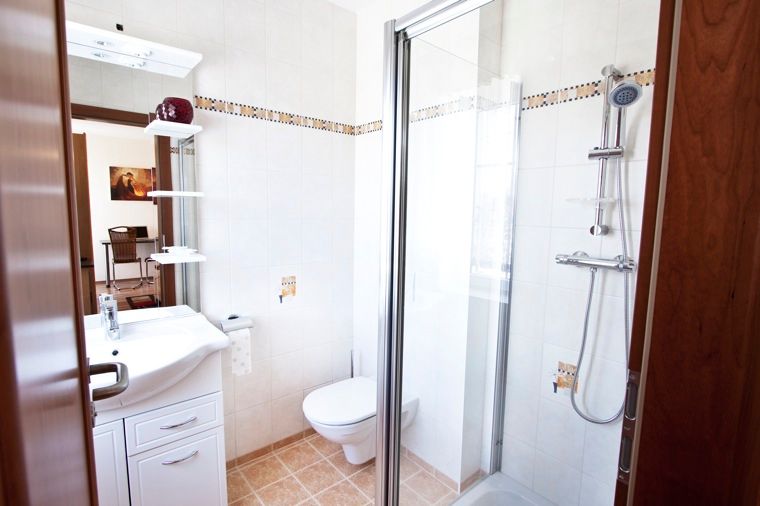 Modernes Badezimmer mit Dusche, Waschbecken und Toilette.