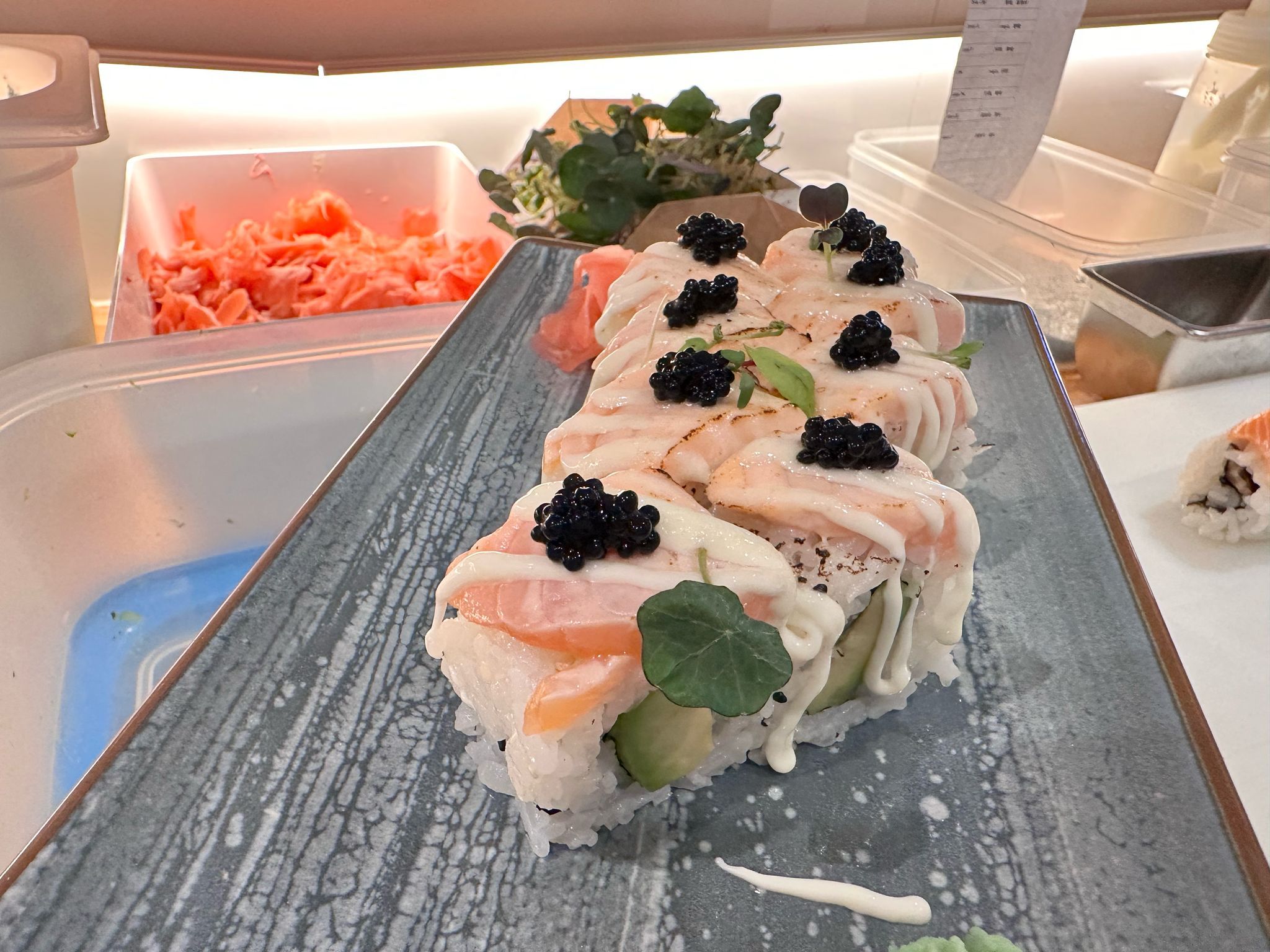 Sushi-Rollen mit Lachs und Kaviar auf einem Teller.