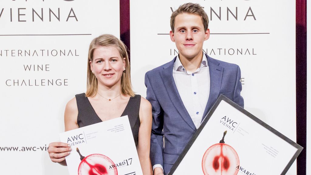 Zwei Personen halten Auszeichnungen bei der AWC Vienna.