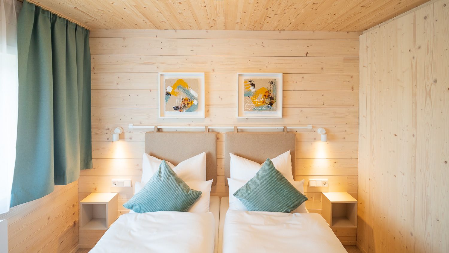 Gemütliches Schlafzimmer mit zwei Einzelbetten, Holzwänden und moderner Dekoration.