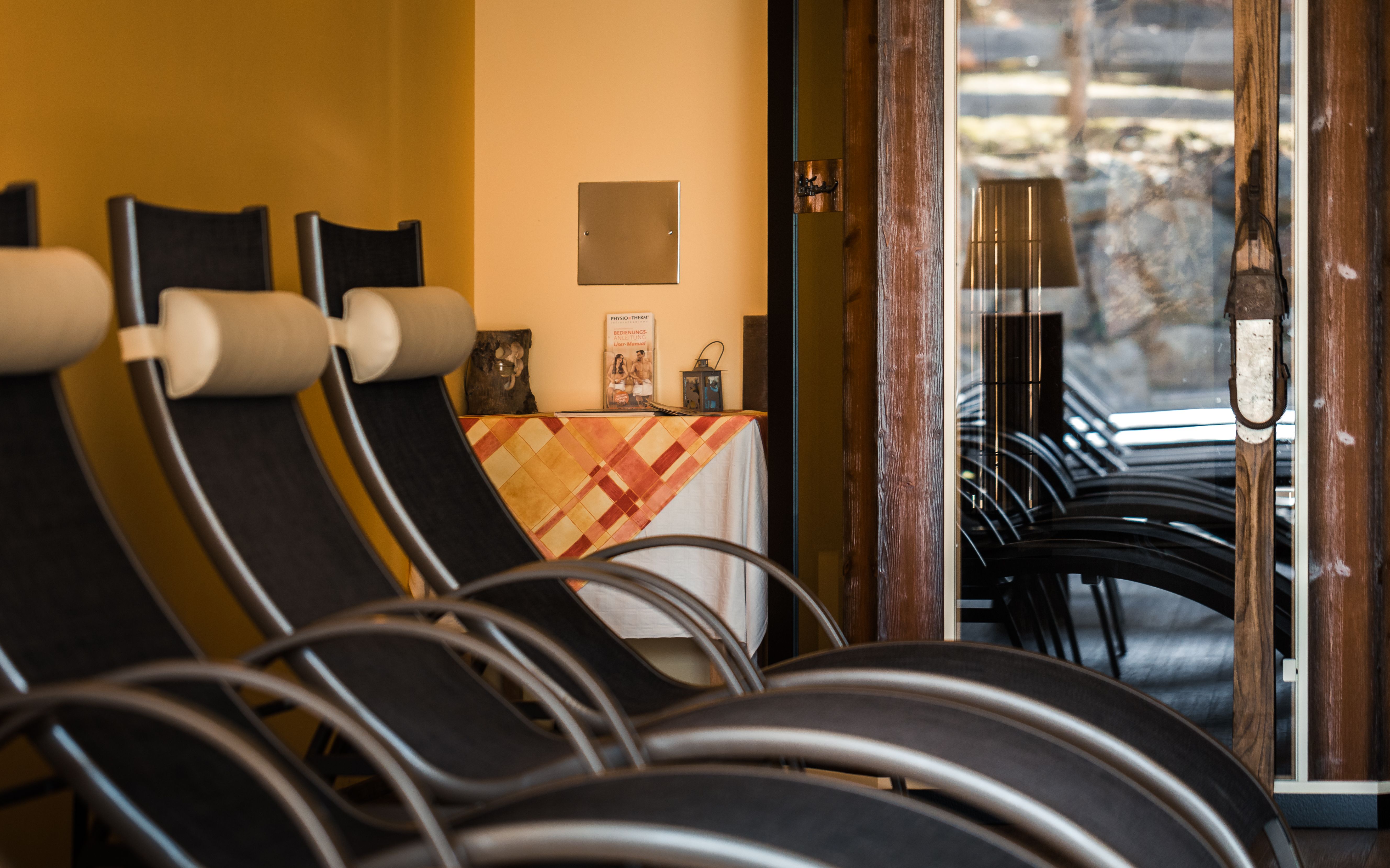 Innenansicht eines Ruheraums mit Liegestühlen und einem Tisch mit Tischdecke.