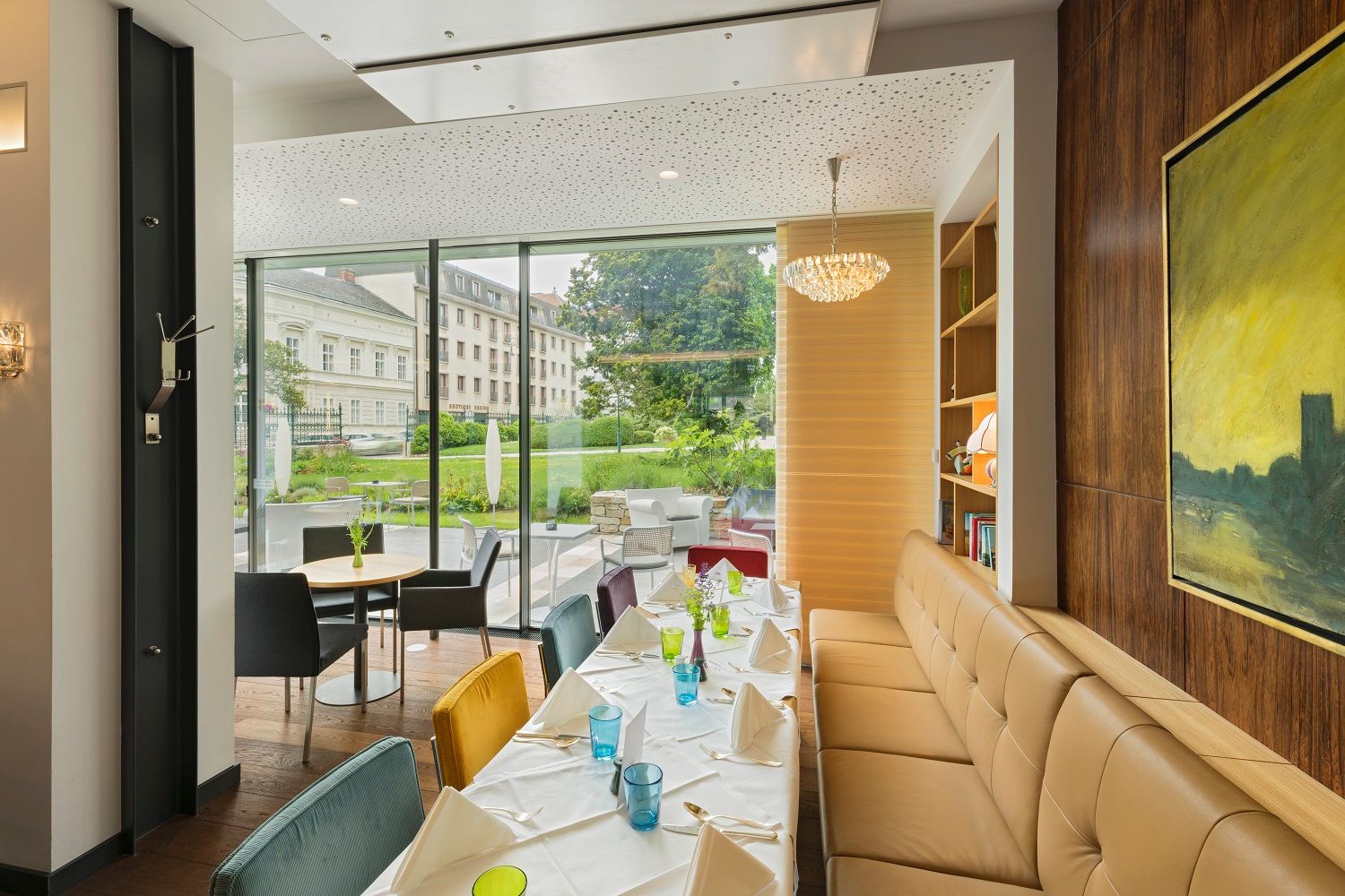 Elegantes Hotelrestaurant mit gedecktem Tisch und Blick auf den Garten.