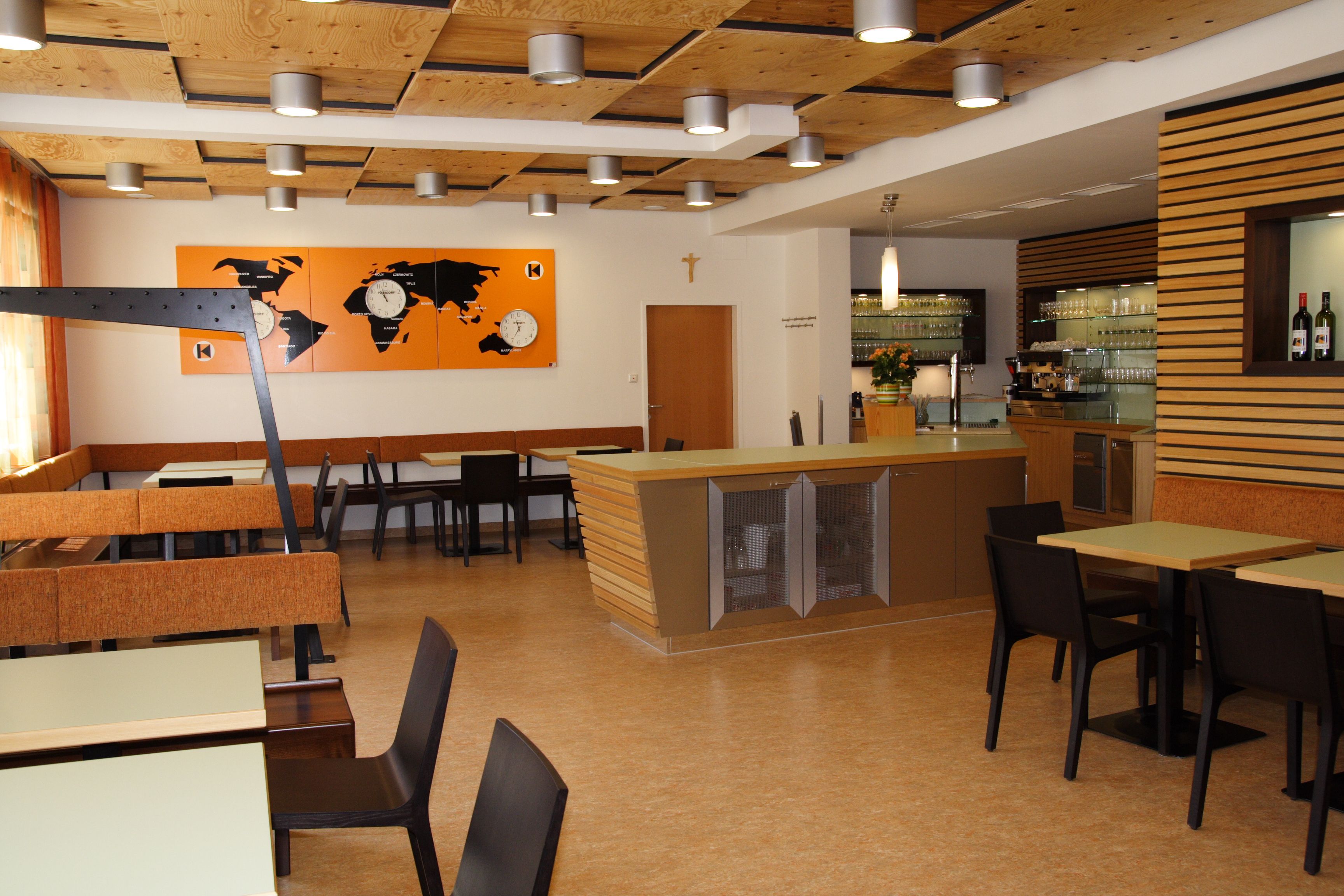 Innenansicht eines modernen Restaurants mit Holzelementen und Weltkarten-Dekor.