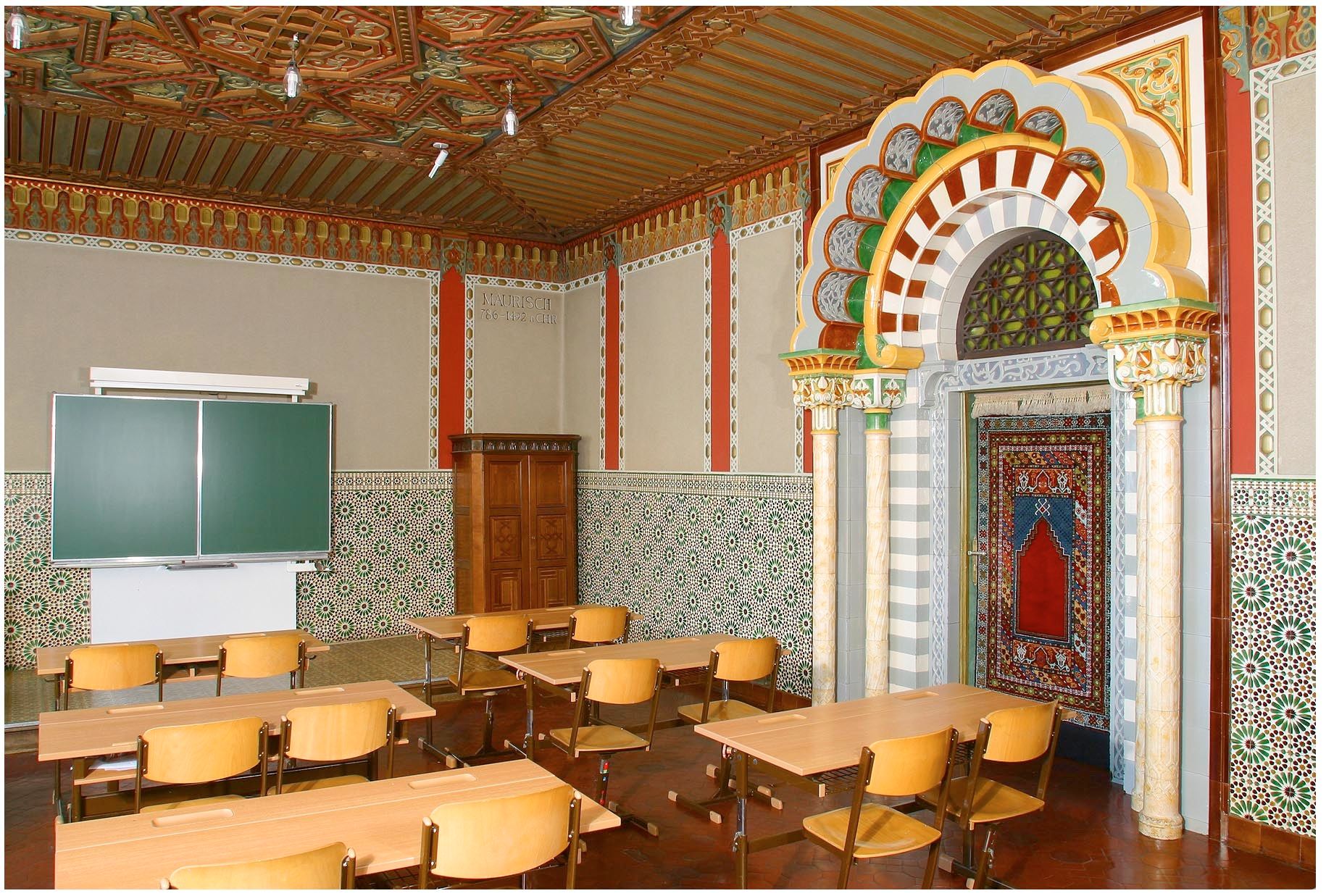 Ein klassenzimmer mit maurischem Dekor, bunten Fliesen und Holzmöbeln.